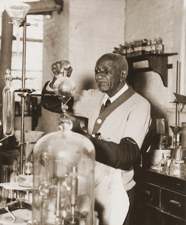 George Washington Carver working with chemistry equipment in his laboratory at Tuskegee University.