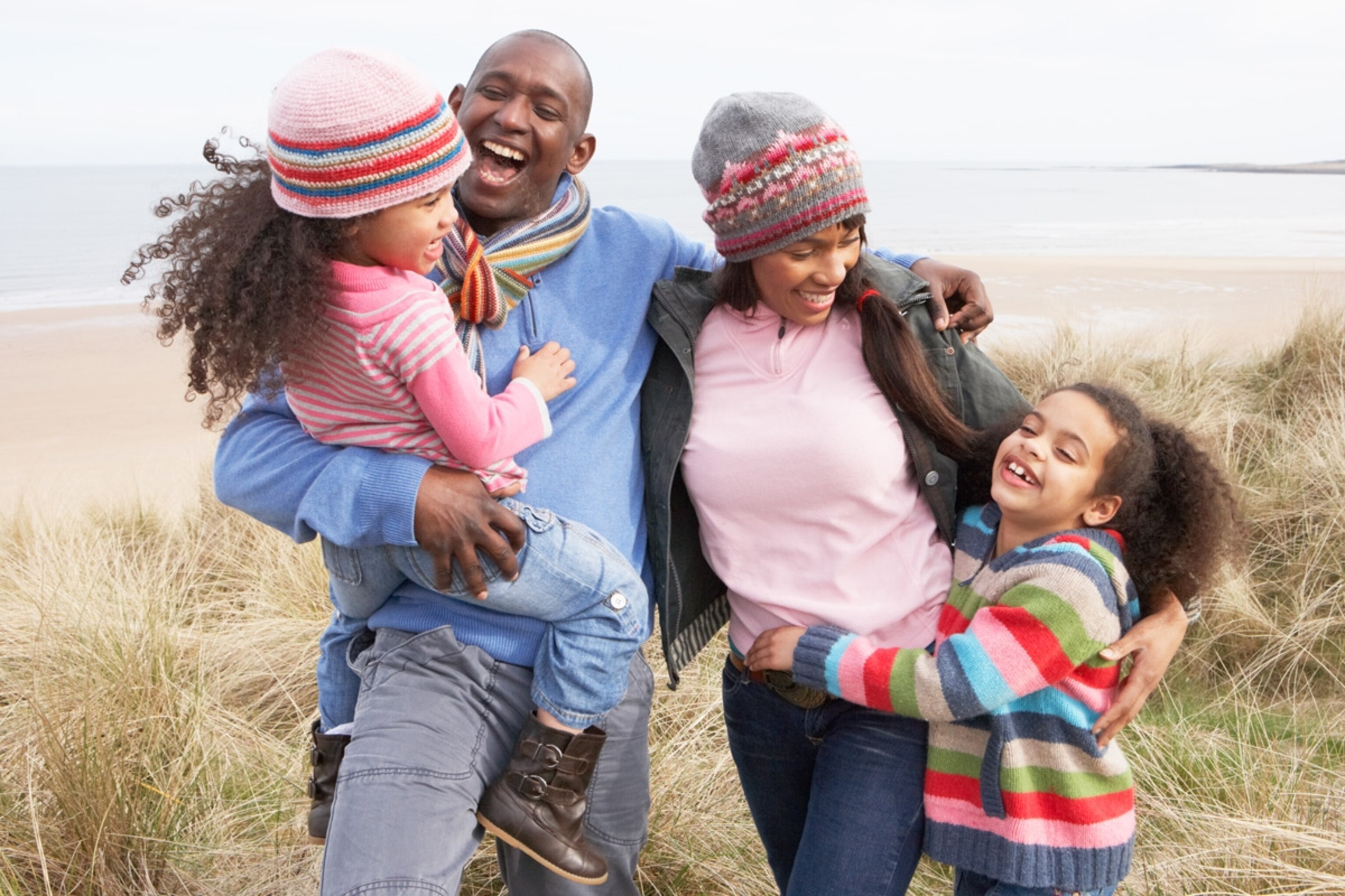 Family Walking Along Dunes On Beach In Wintertime.