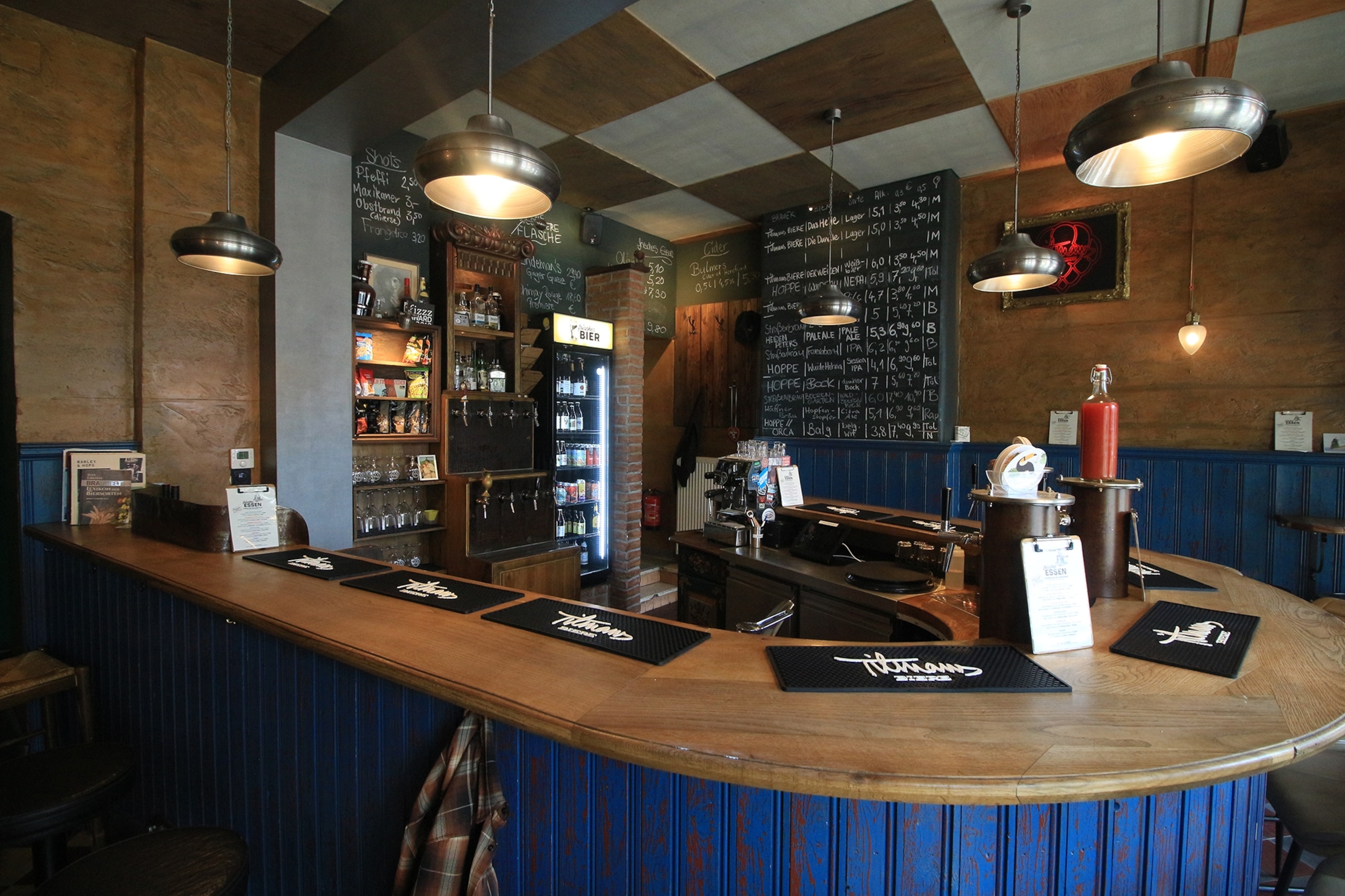 The interior of a modern bar with a circular counter and draft beer on offer.