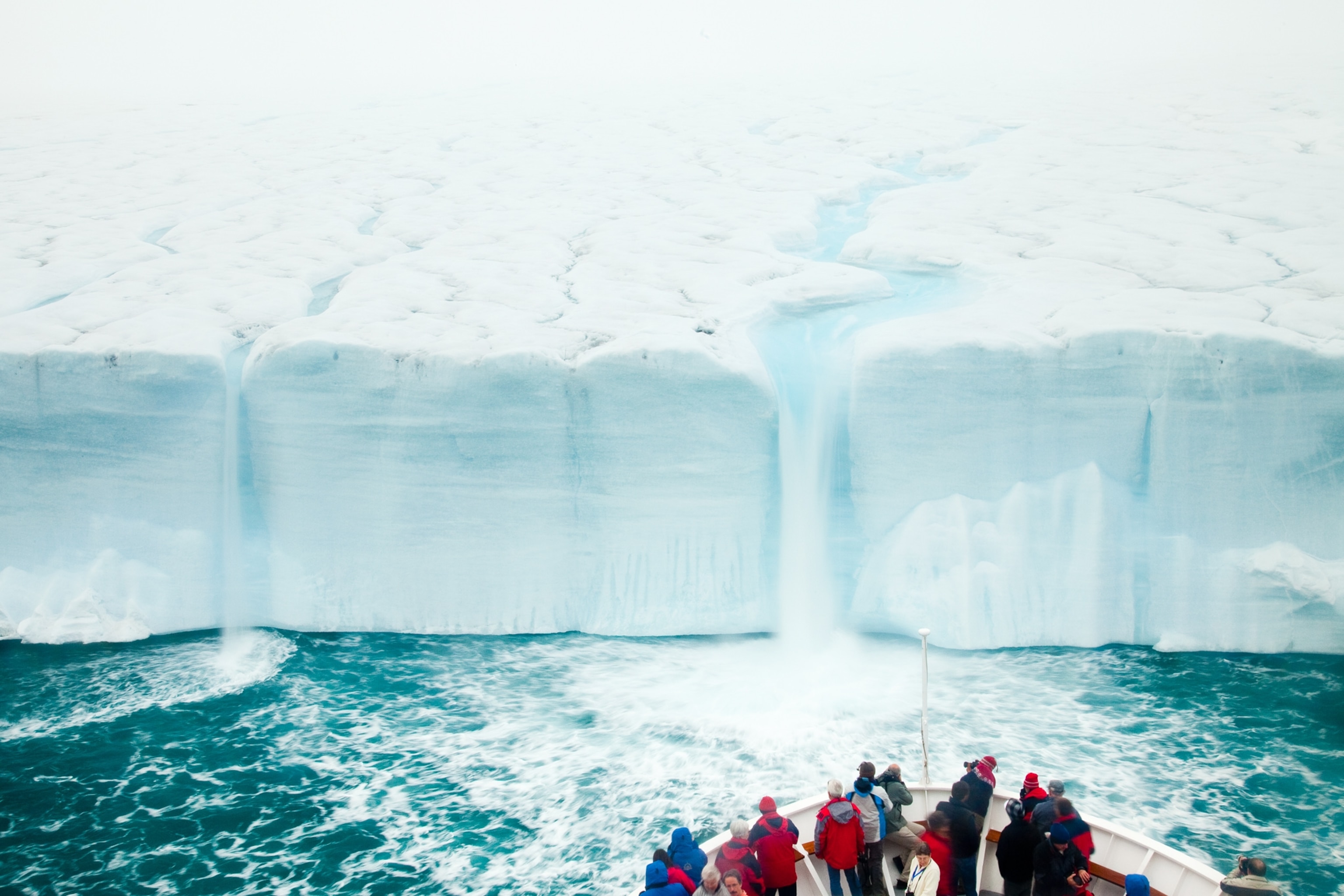 Summer meltwater forms a waterfall on an ice cap.