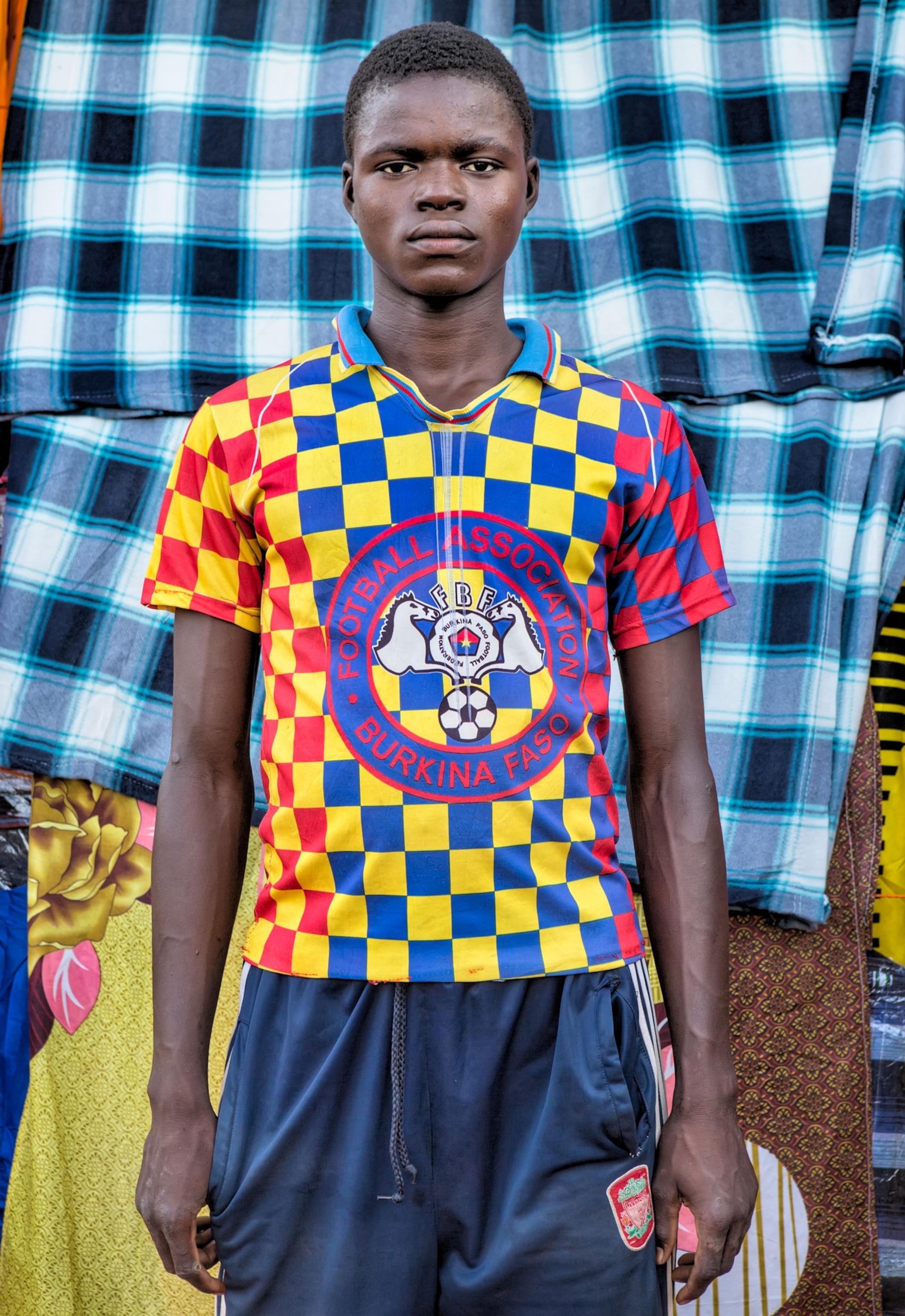 a young man shopping at an outdoor market in Burkina Faso