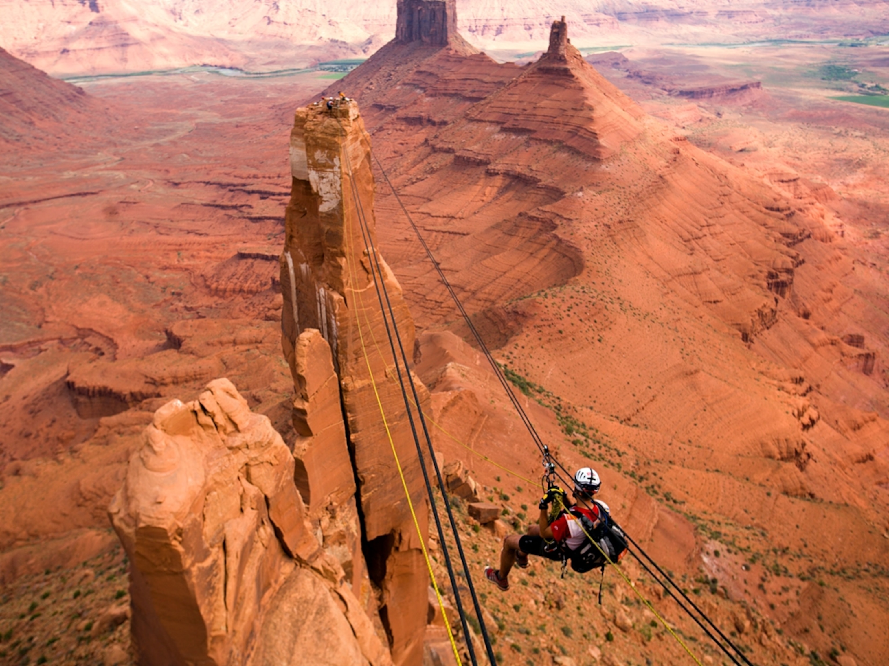 Man crossing rope over canyon