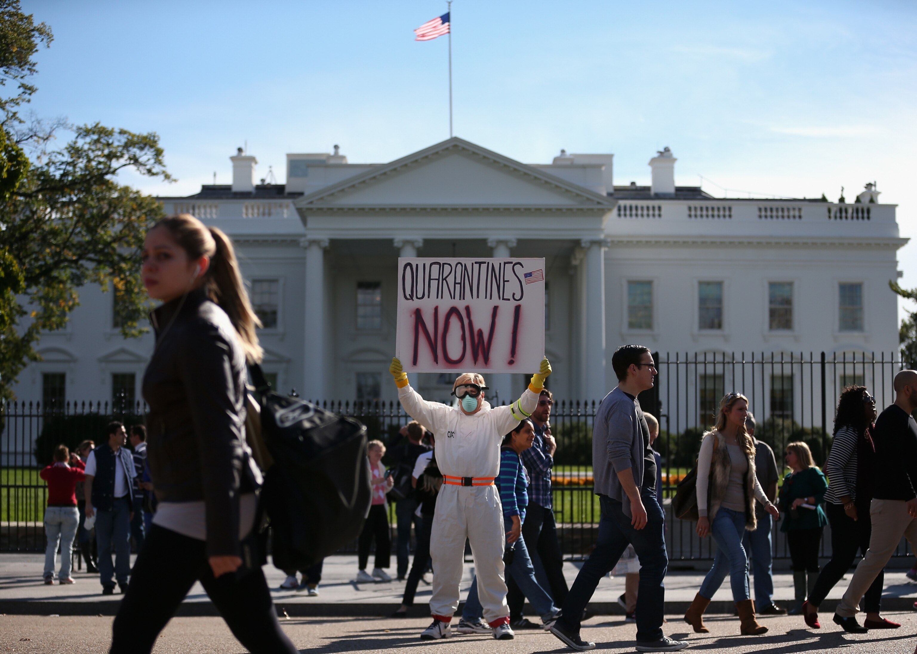 a protestor with a sign in front of the White House.