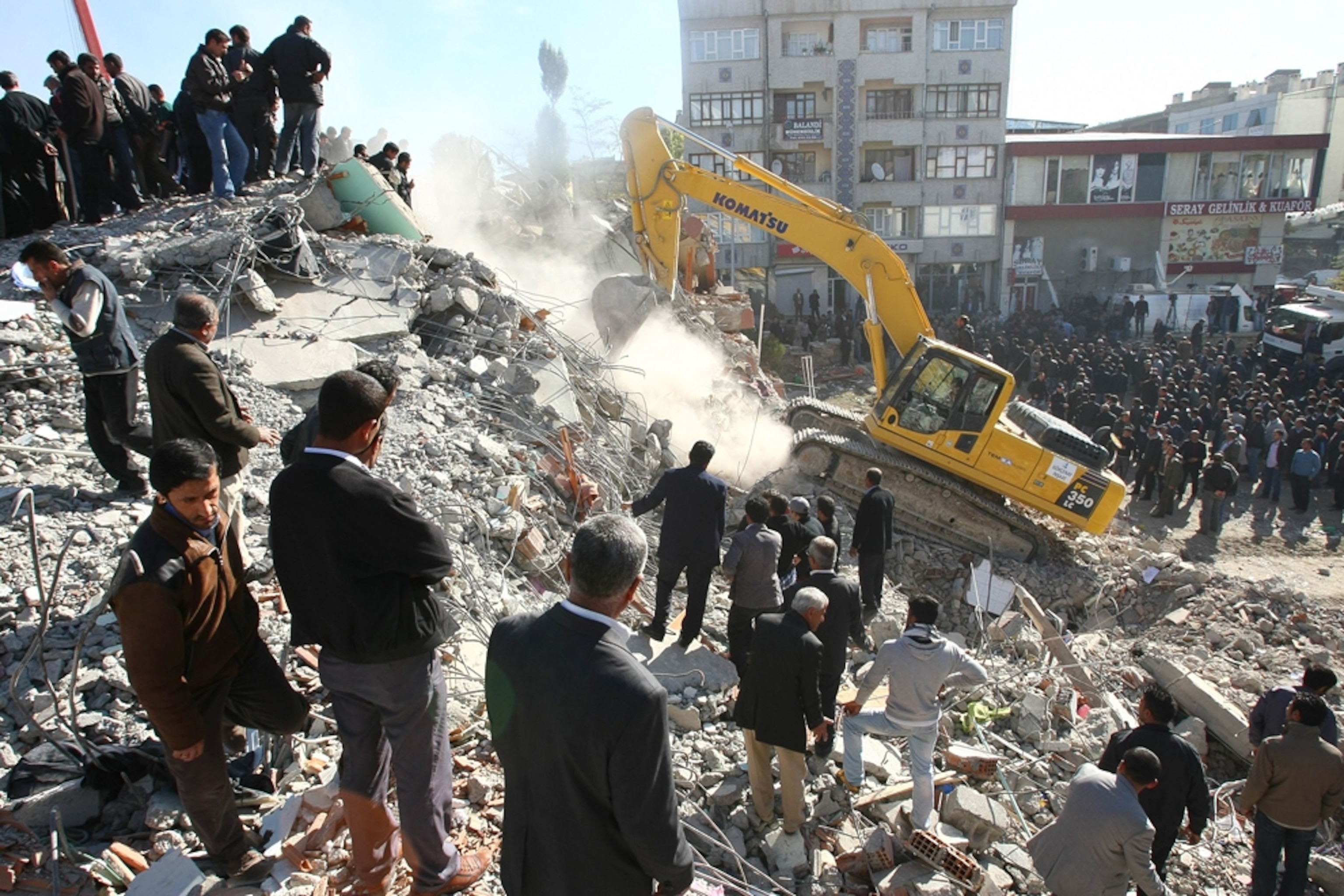 Turkey earthquake picture: People watch as a crane digs through rubble