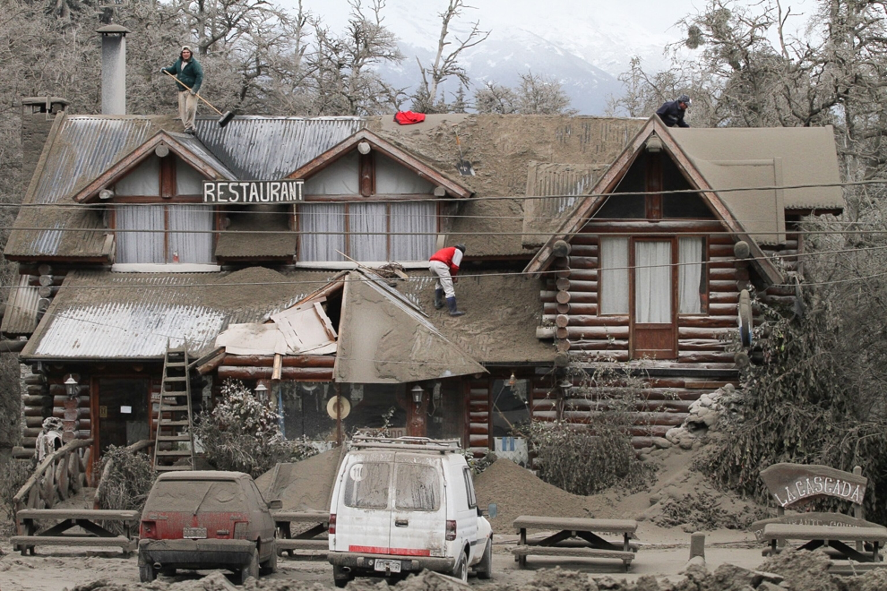Volcano picture: workers cleaning ash off a roof in Argentina