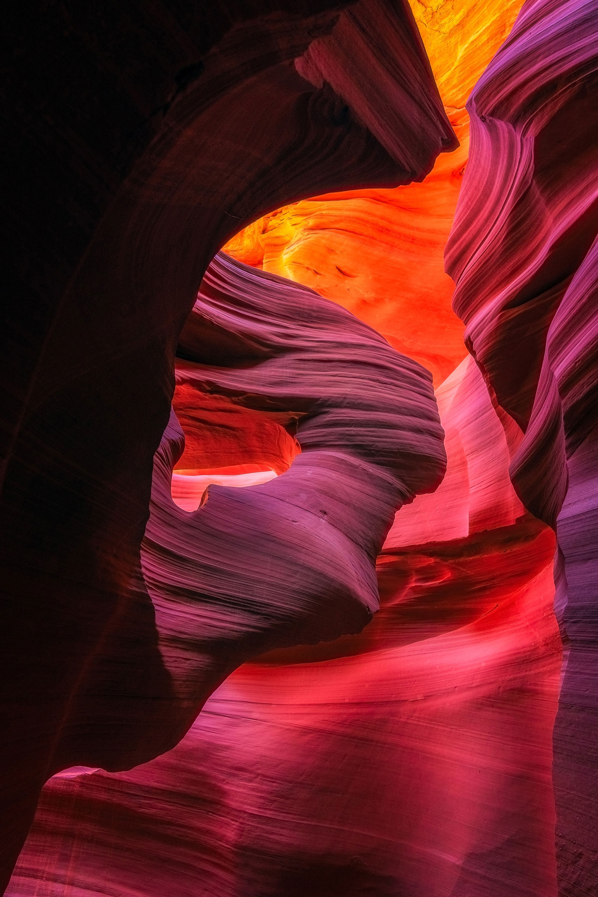 A view of pink and orange canyons illuminated in the sun.