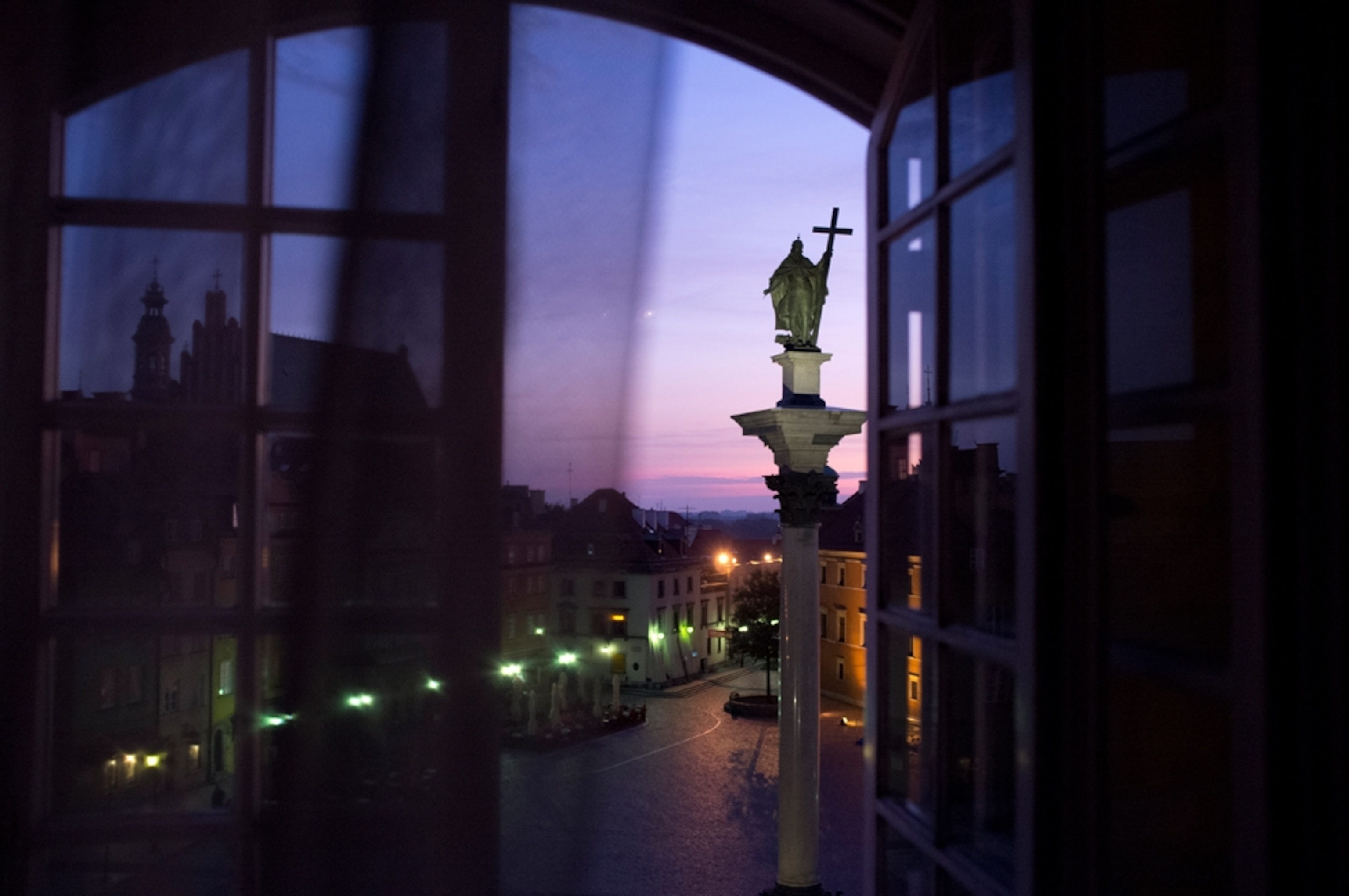 a view out a window of Warsaw, Poland at dawn