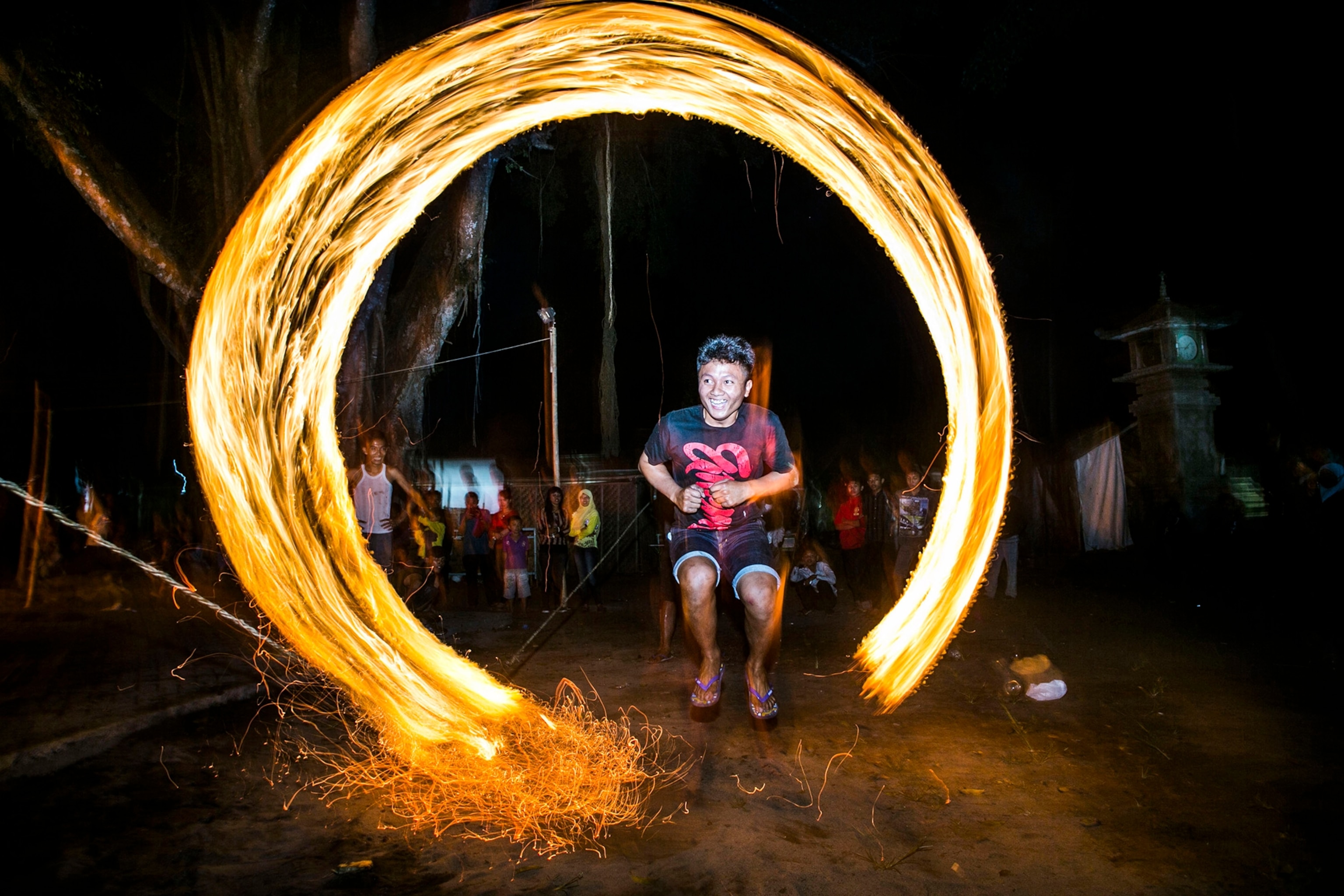 An Indonesian youth jumps through flaming rope during a traditional celebration marking the end of the holy fasting month of Ramadan, in Srandakan, near Yogyakarta, Indonesia, late Thursday, Aug. 8, 2013.