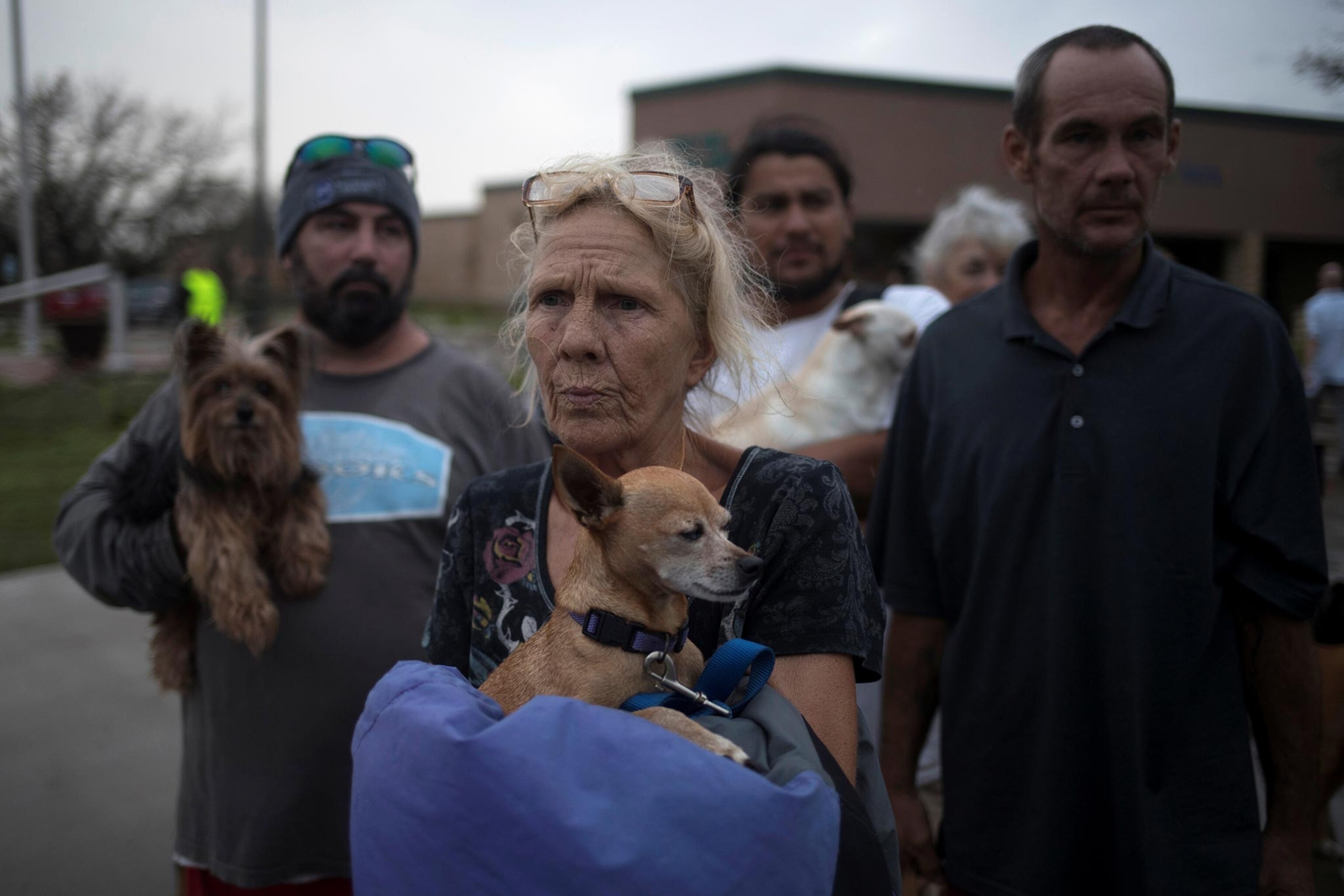 Julie holds her dog Pee-wee as they stand in line to be evacuated to Austin