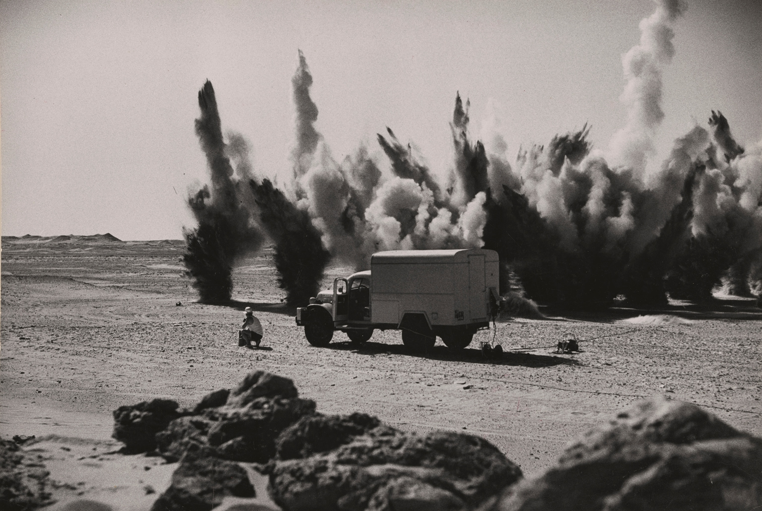 Dynamite hurls geysers of sand above the desert as French oil geologists sound the depths with seismographic instruments.
