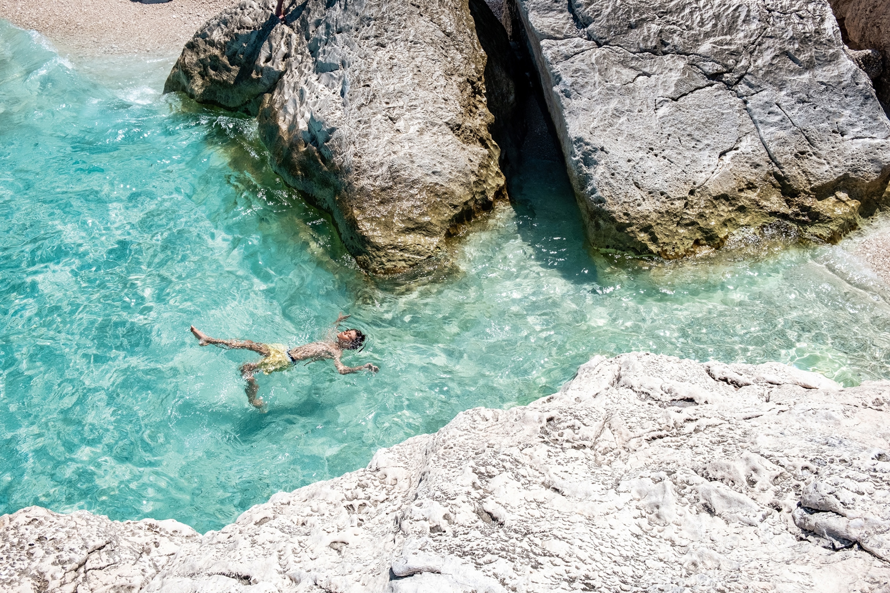 A swimmer relaxing on his back in crystal clear waters