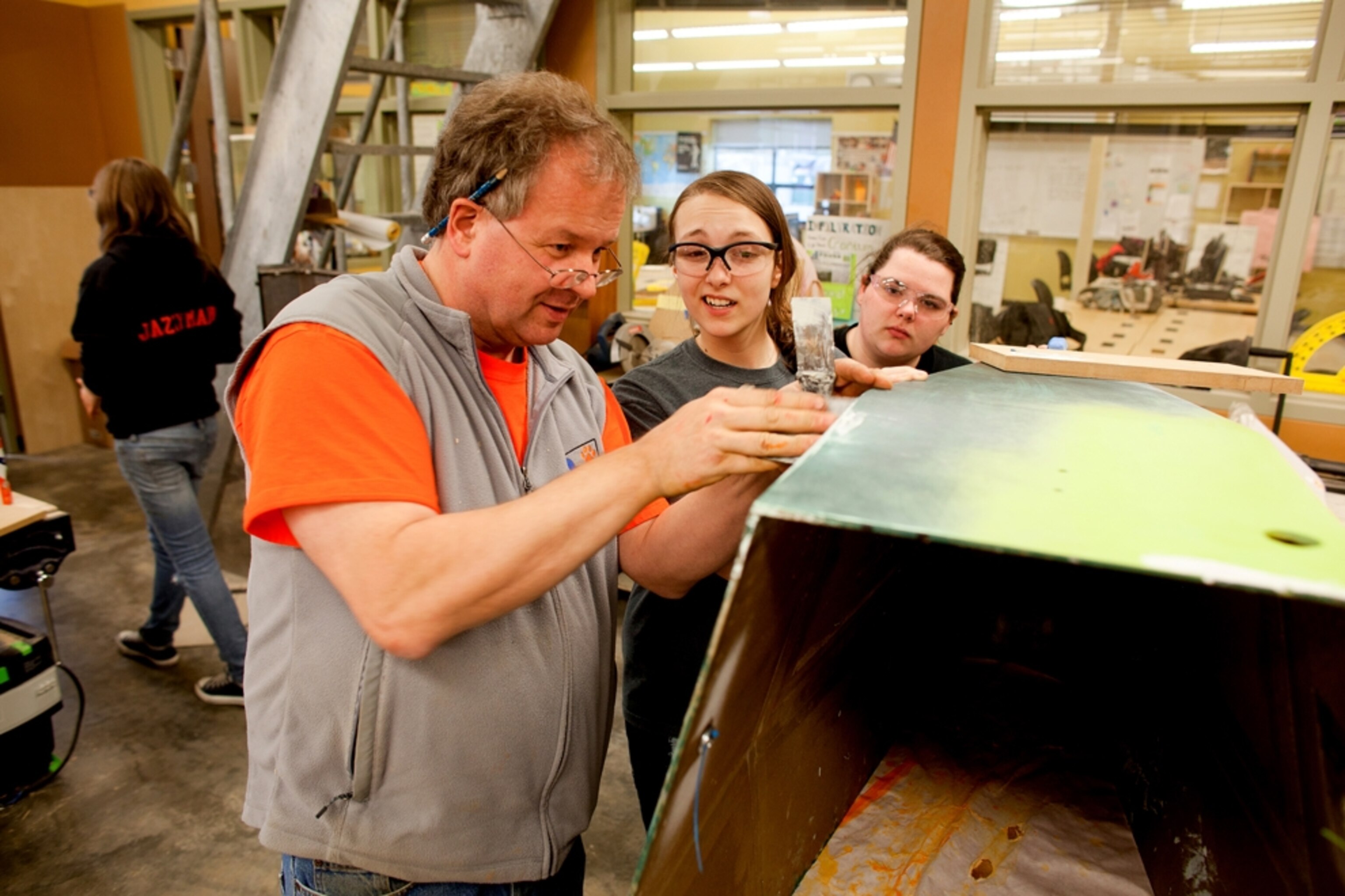 Instructor Michael Werner demonstrates filler putty technique to two of the ShopGirls