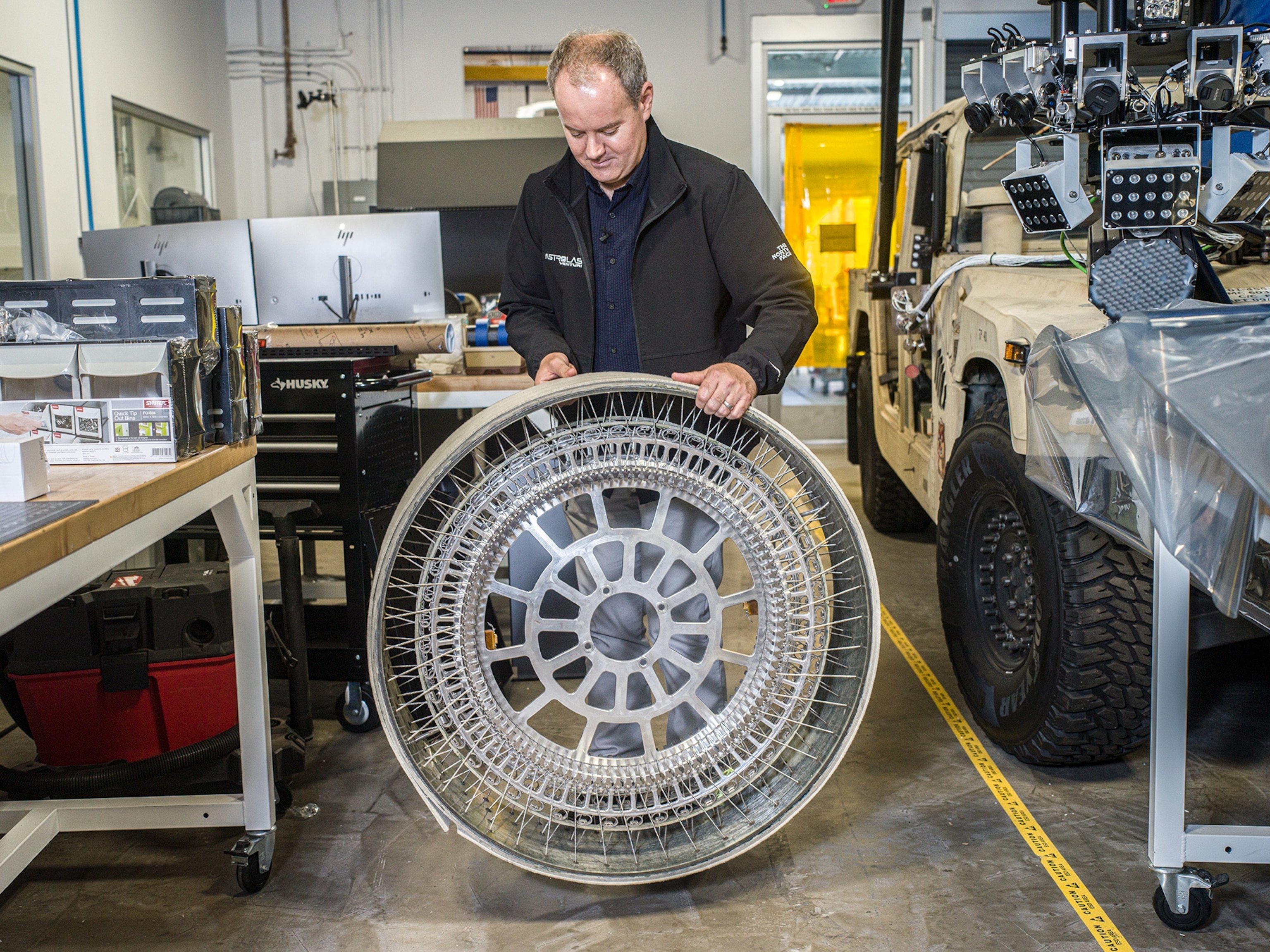 man bouncing steel tire on ground in a lab