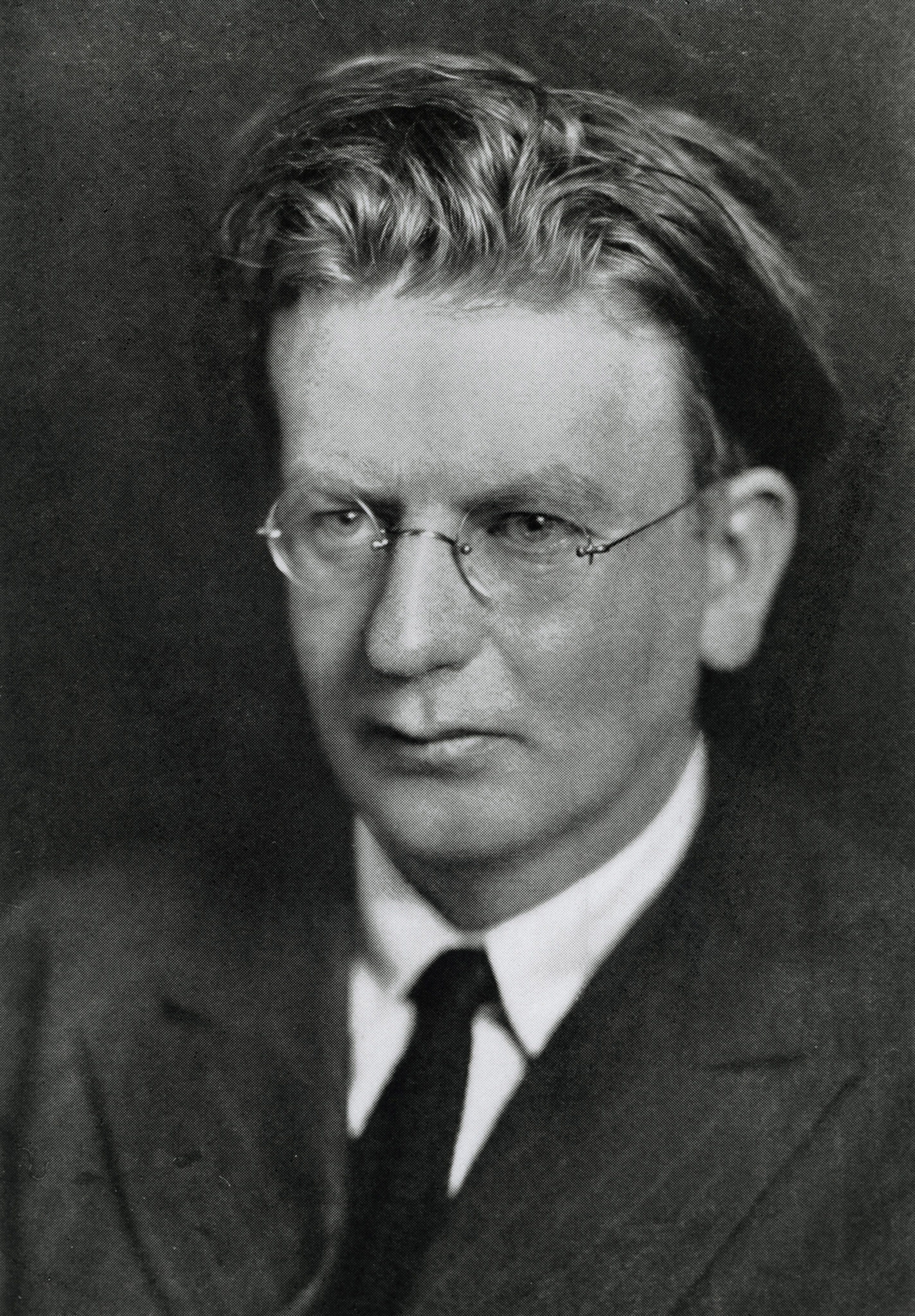Black and white portrait of a gentleman wearing suit and tie and glasses