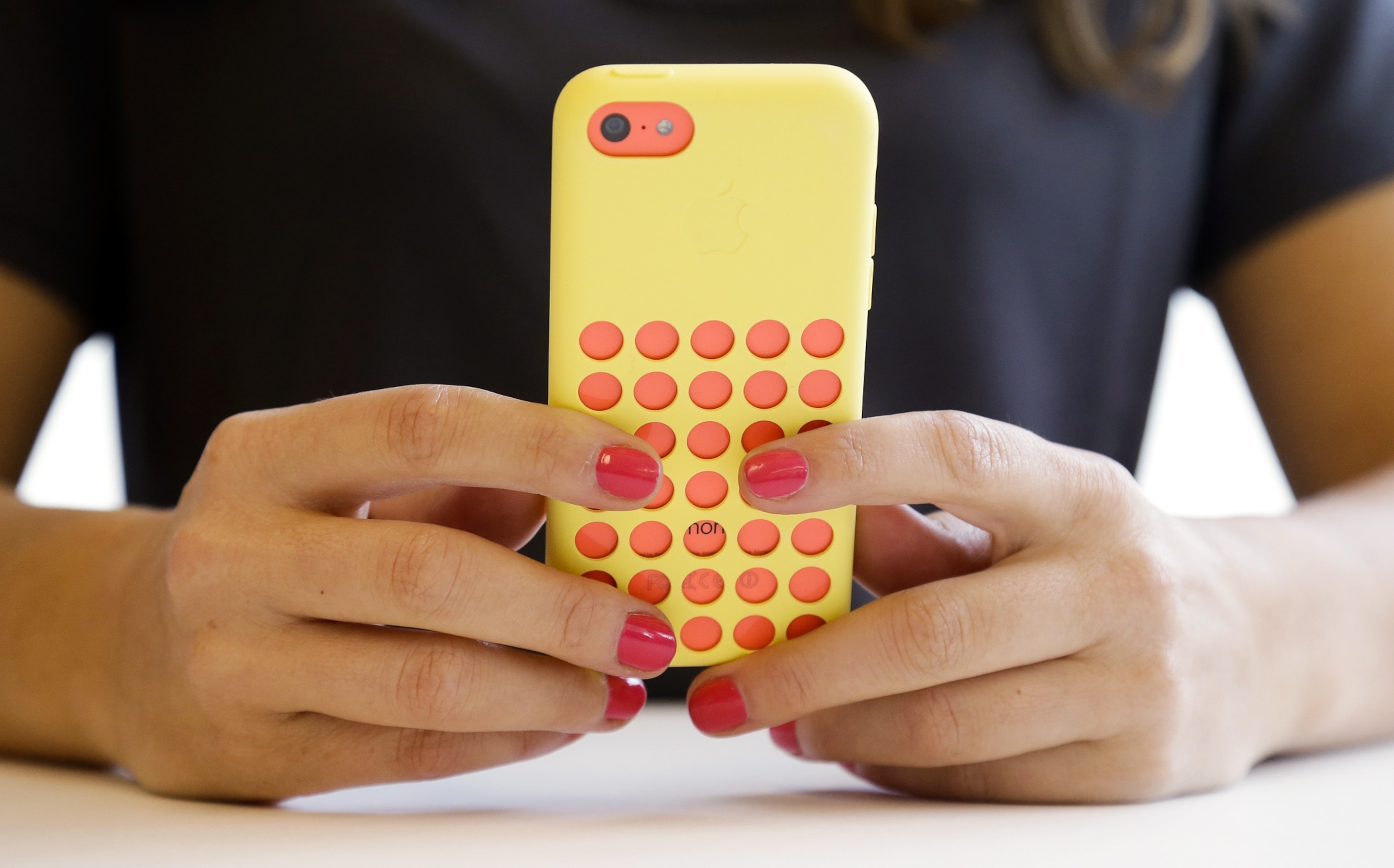 A journalist looks at a new iPhone.