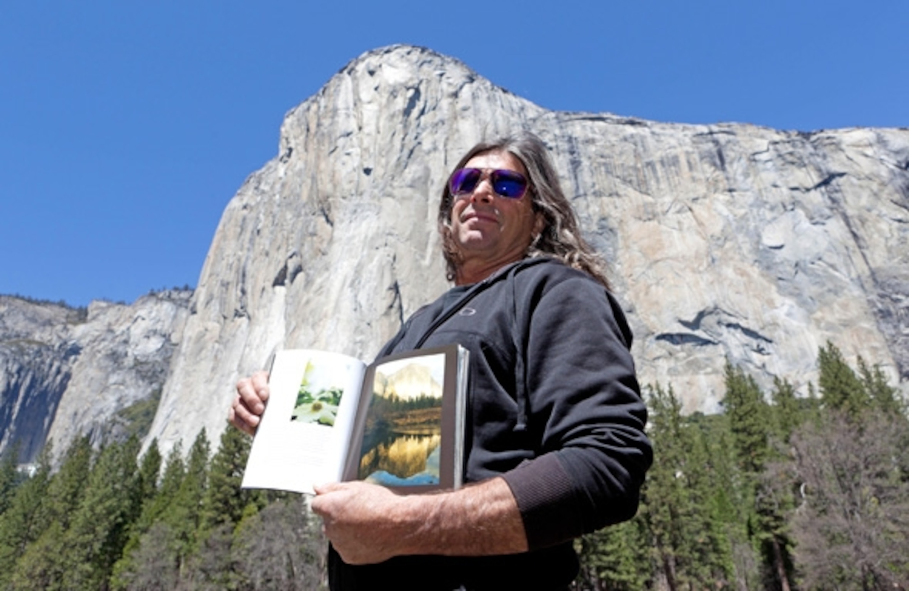 Ron Kauk holding a book he wrote about his experience working with incarcerated youth. (Photograph by Shannon Switzer)