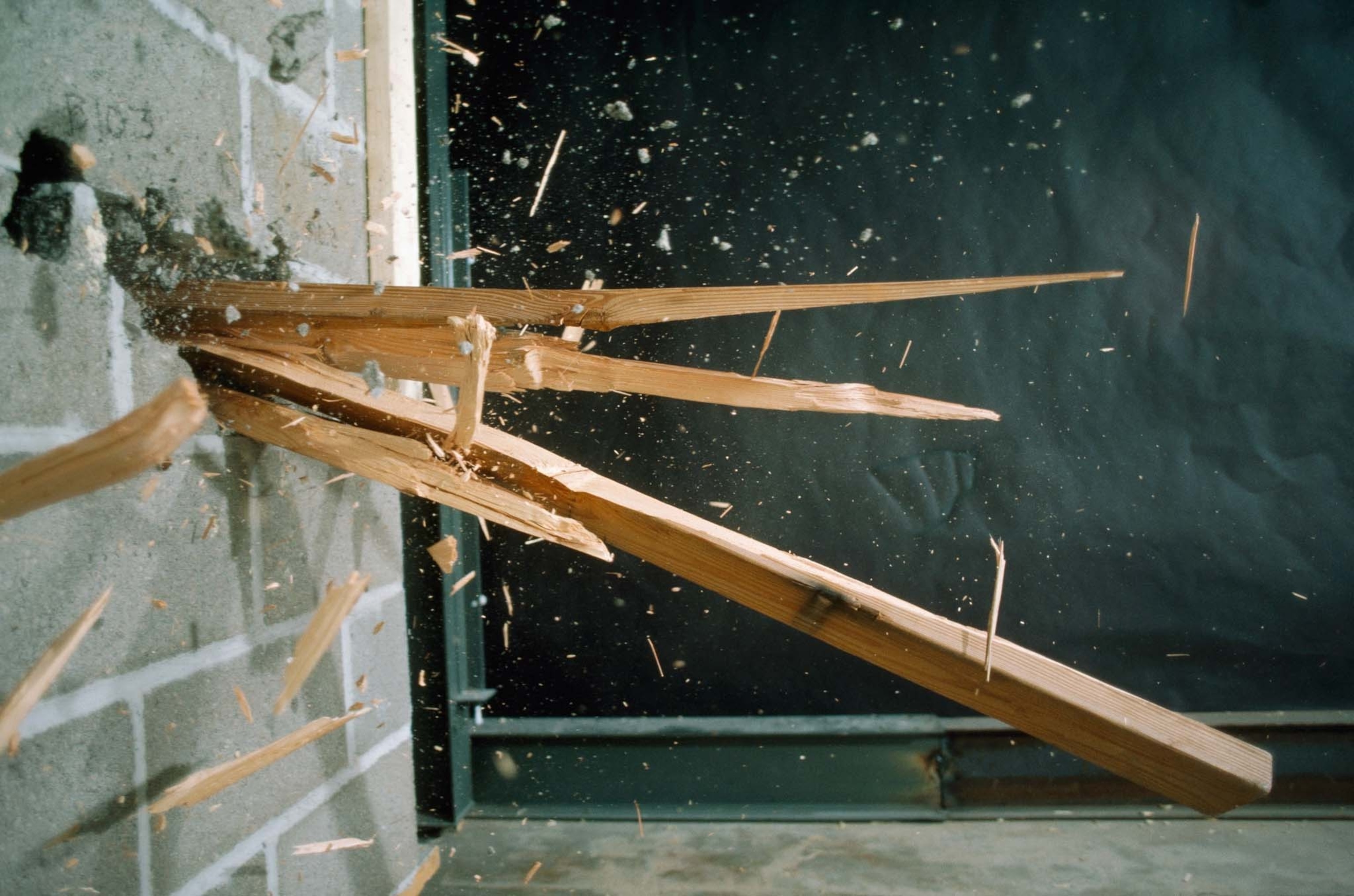 wood splintering through cinderblock