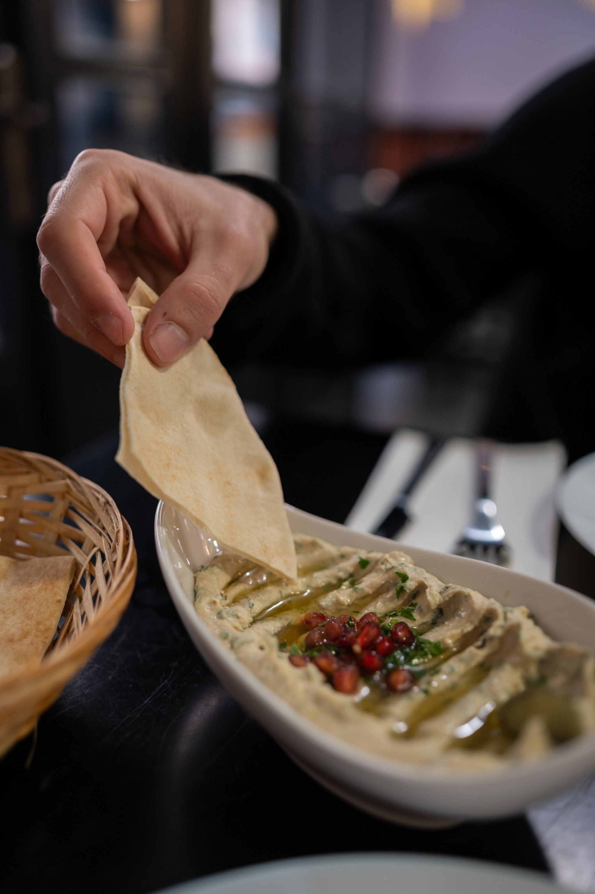A piece of flat bread is being held by a hand.