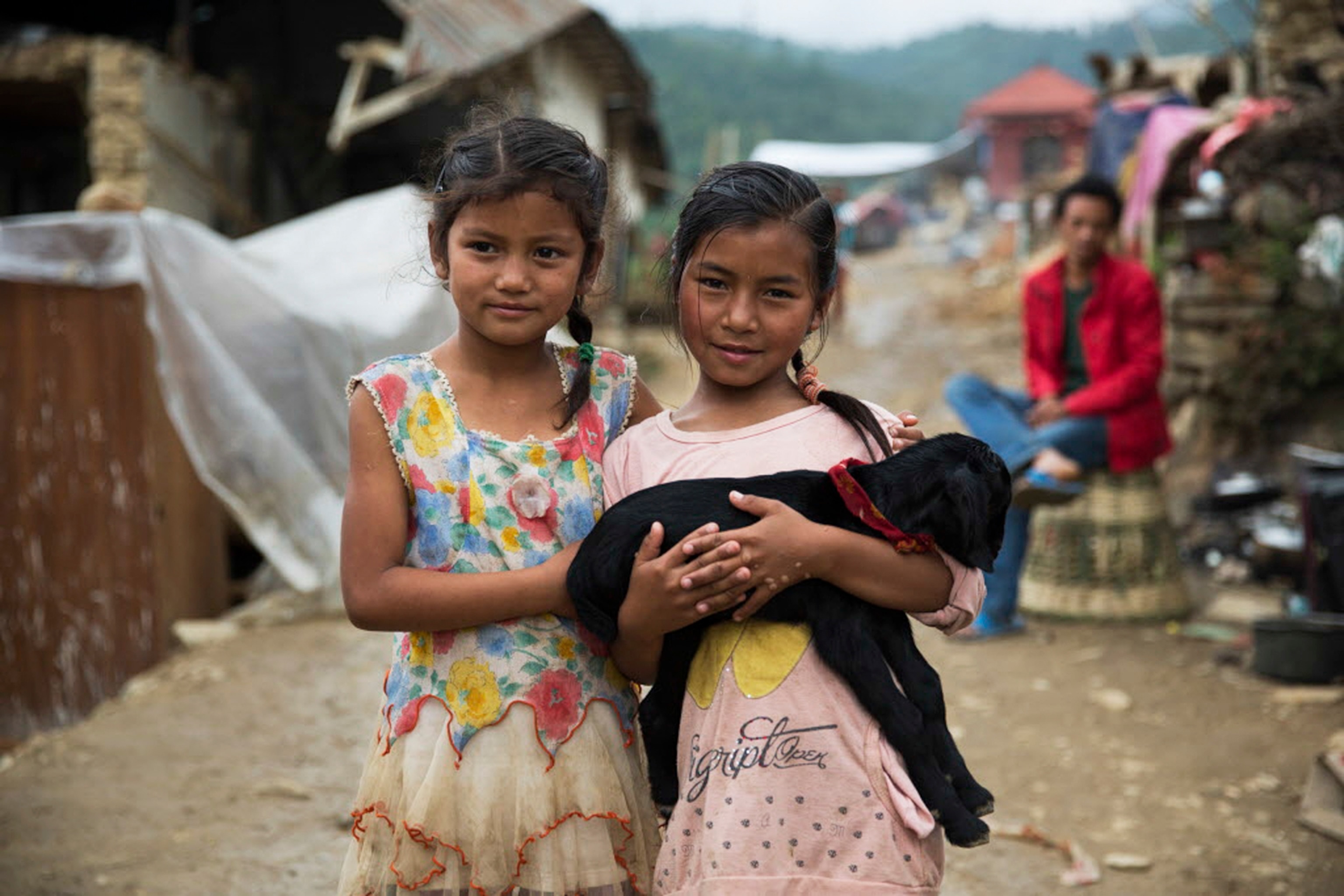 two young girls holding a baby goat