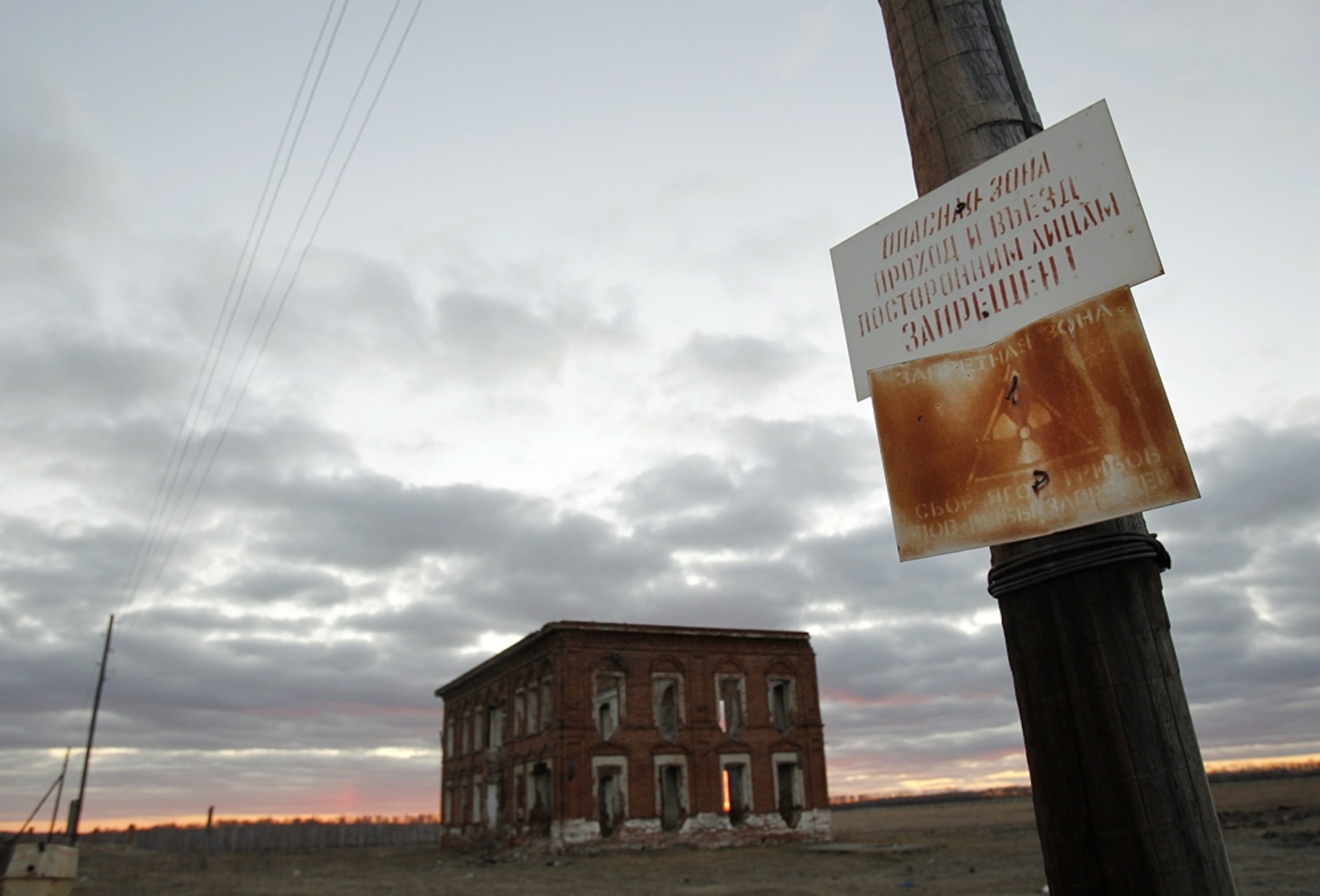 A Russian sign, near an abandoned building, warns of toxic waste.
