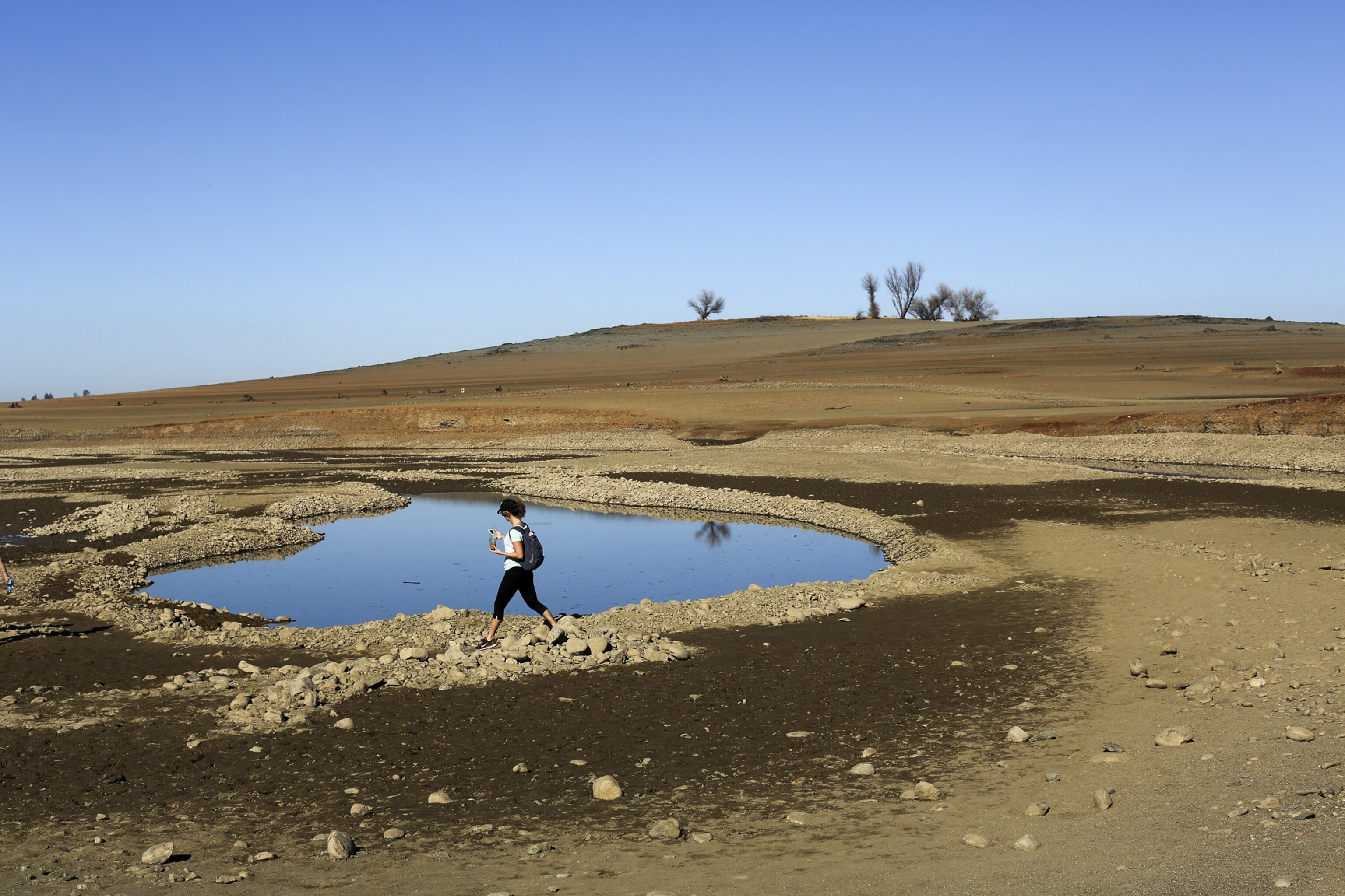 a visitor near the receding waters at Folsom Lake.