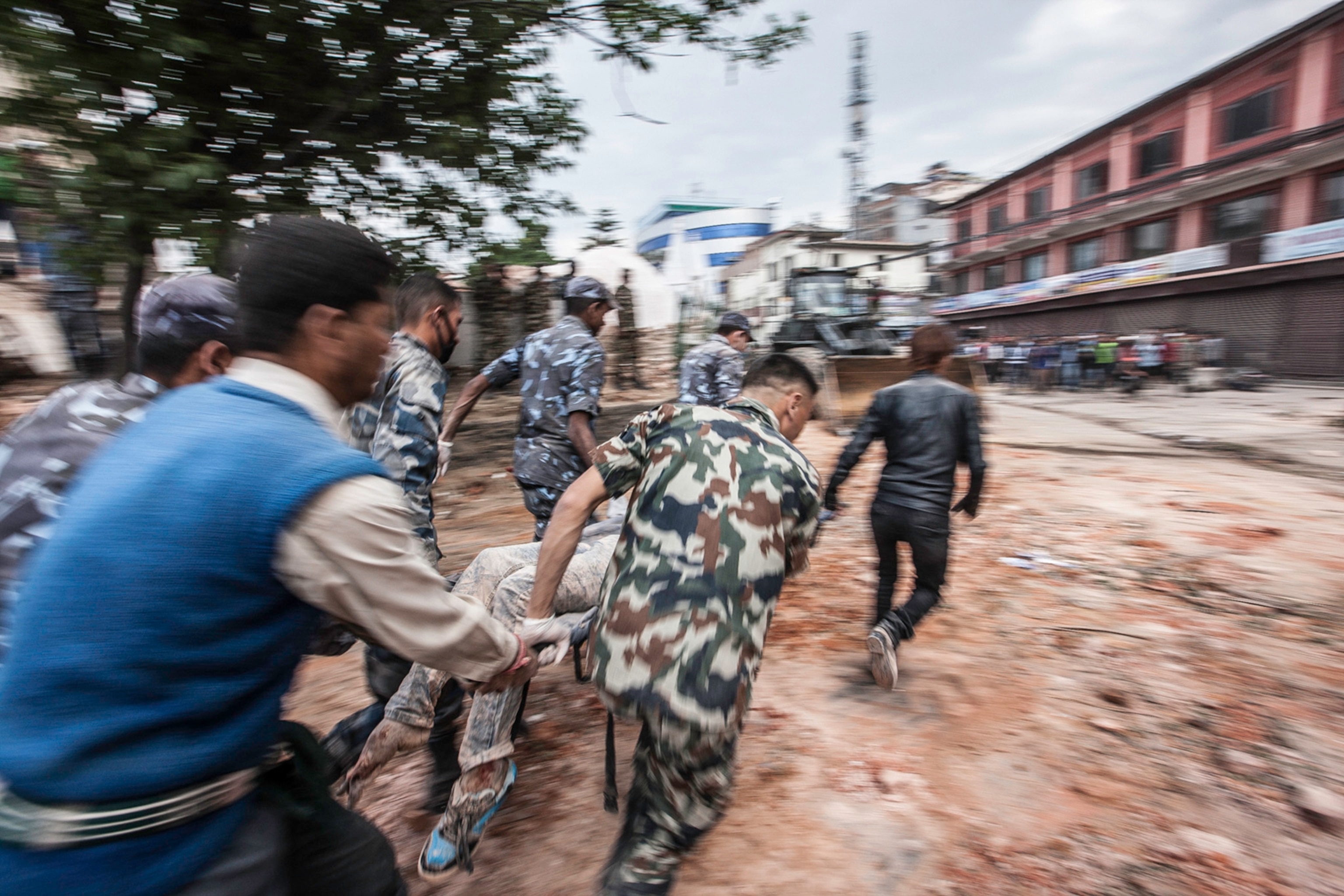 Picyture of Rescuers rush body off on stretcher in Katmandu, Nepal