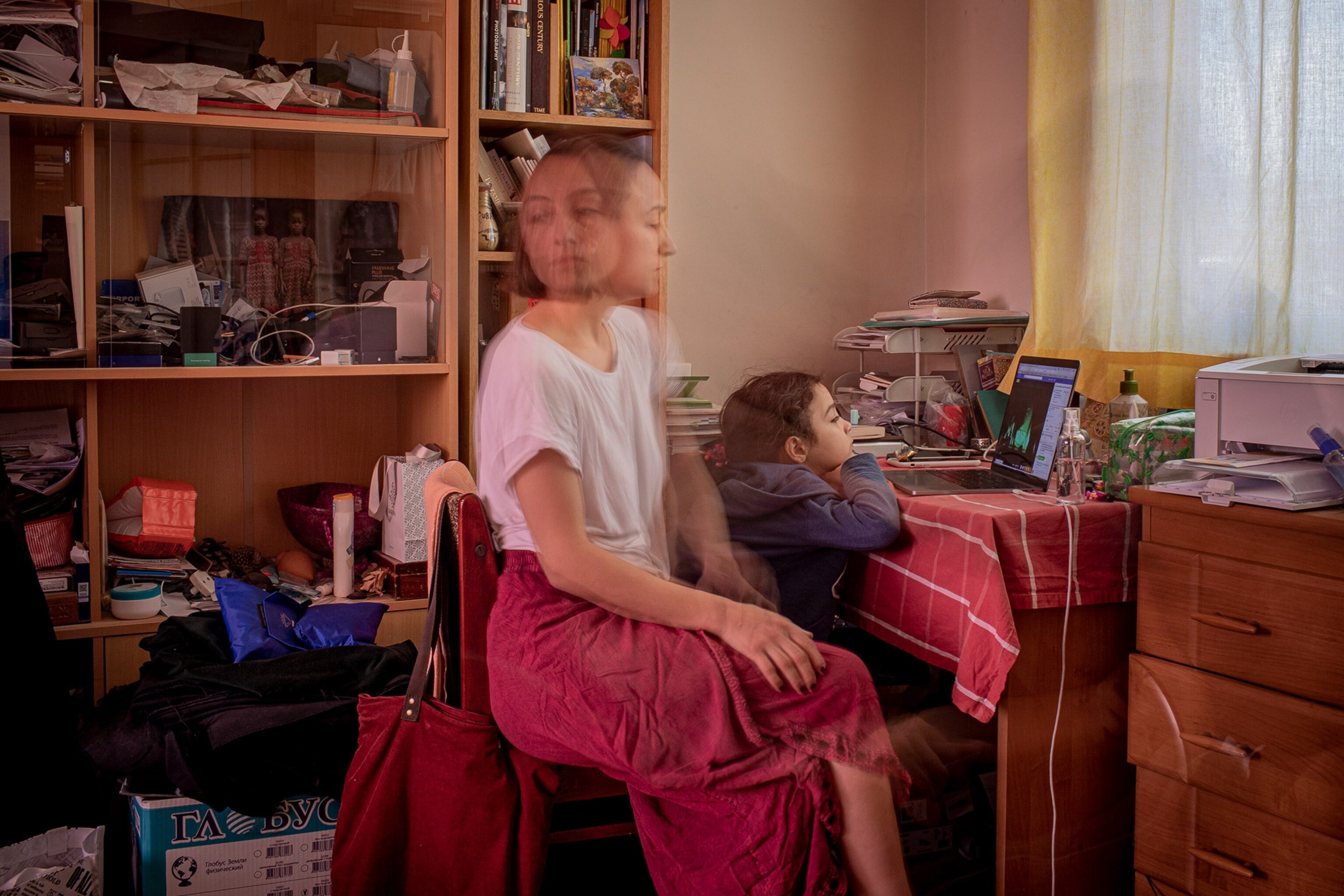 a woman sitting at a desk with her daughter