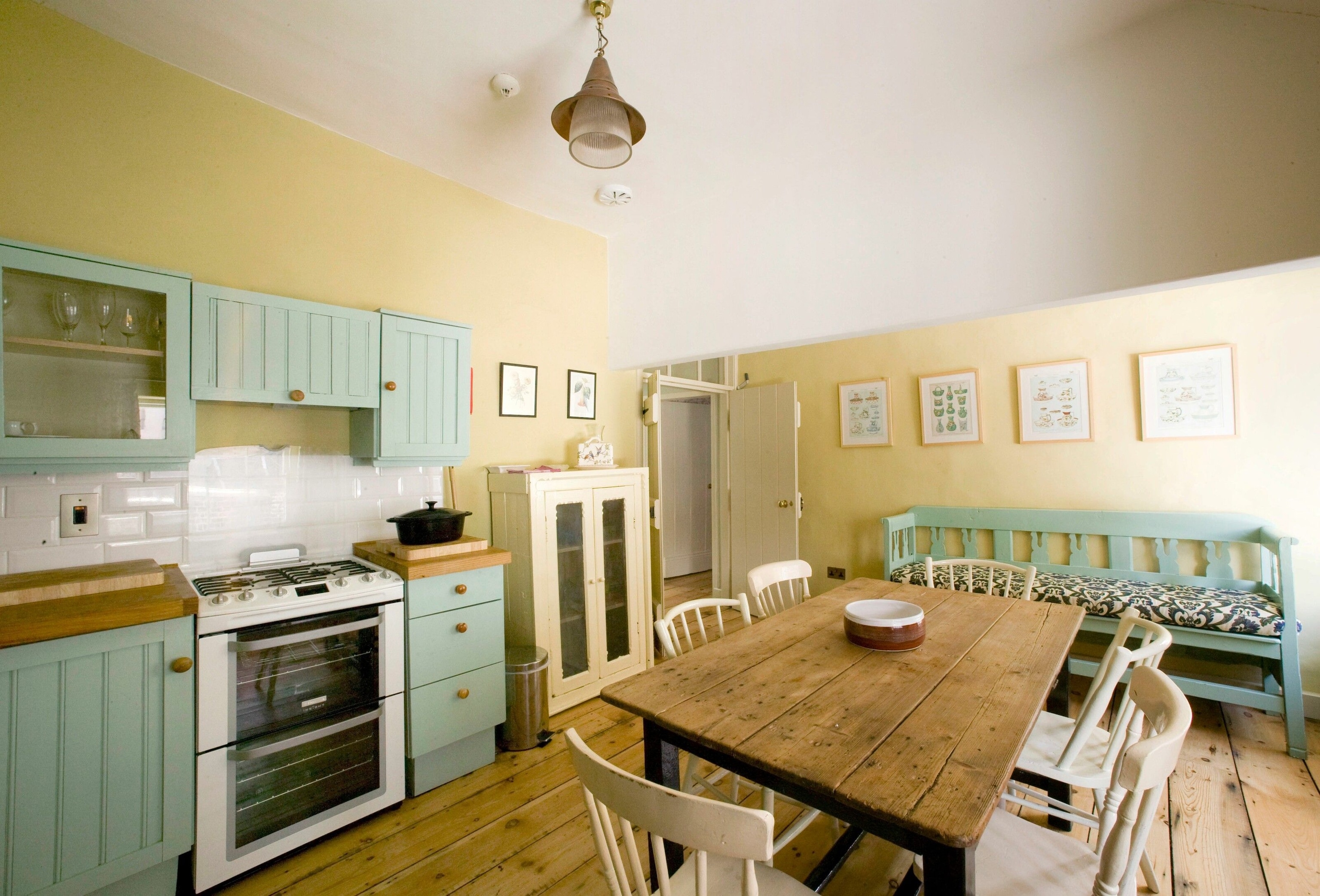 country-style kitchen and bedrooms with wood panelling, flowery wallpaper and antique furnishings
