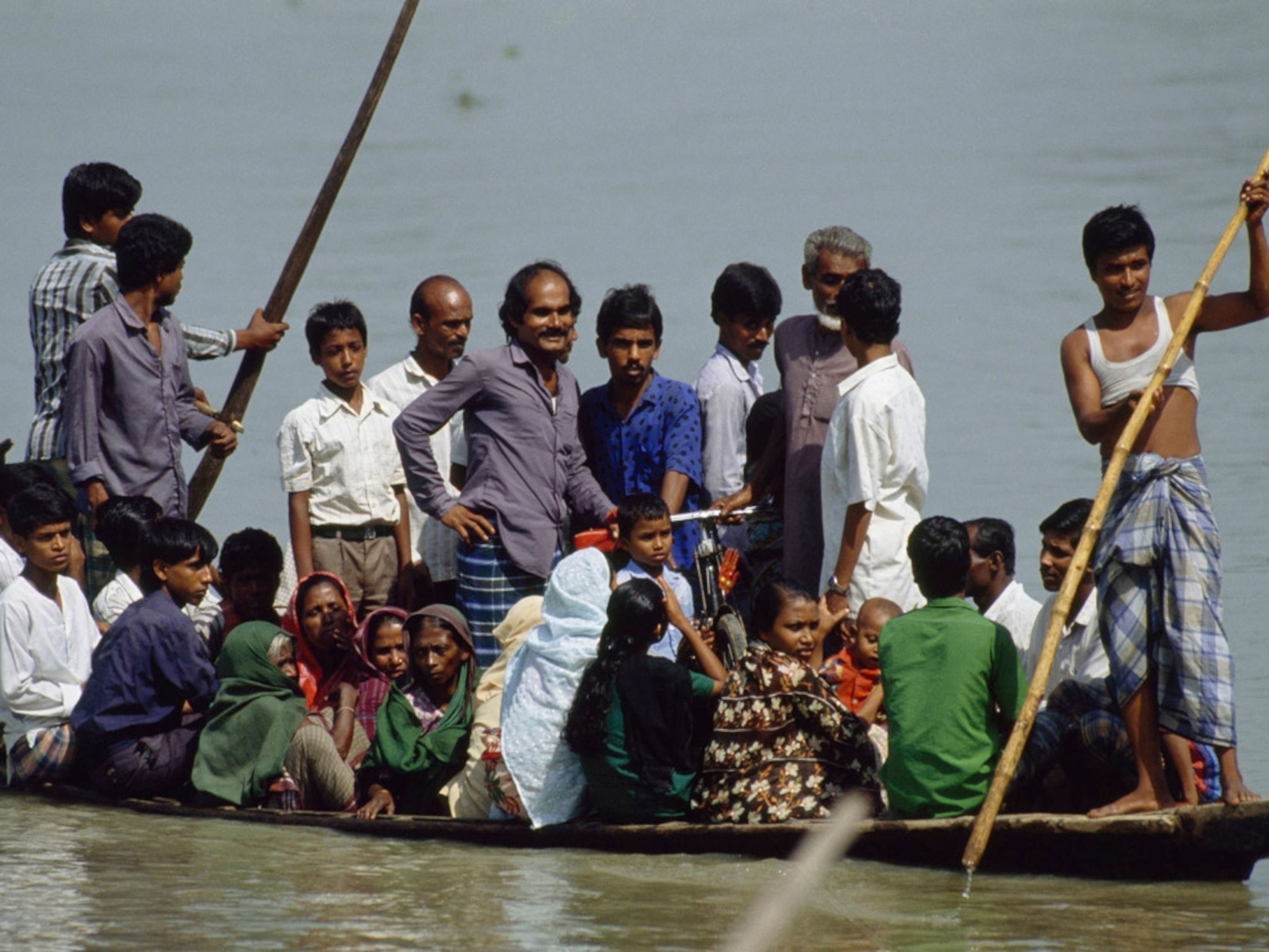 An overcrowded boat sails down the Lakhya River