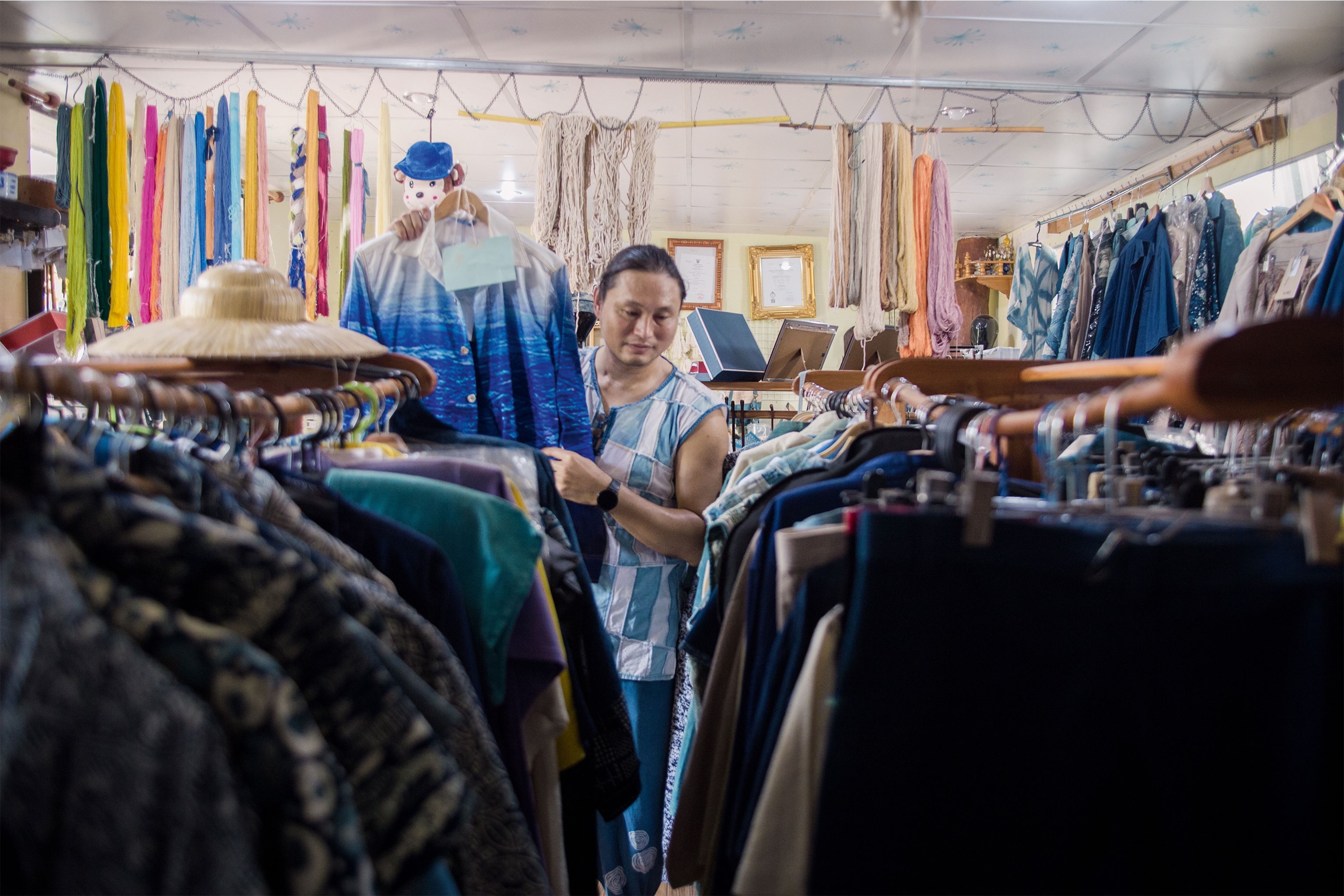 Passakorn sorting garments in his store