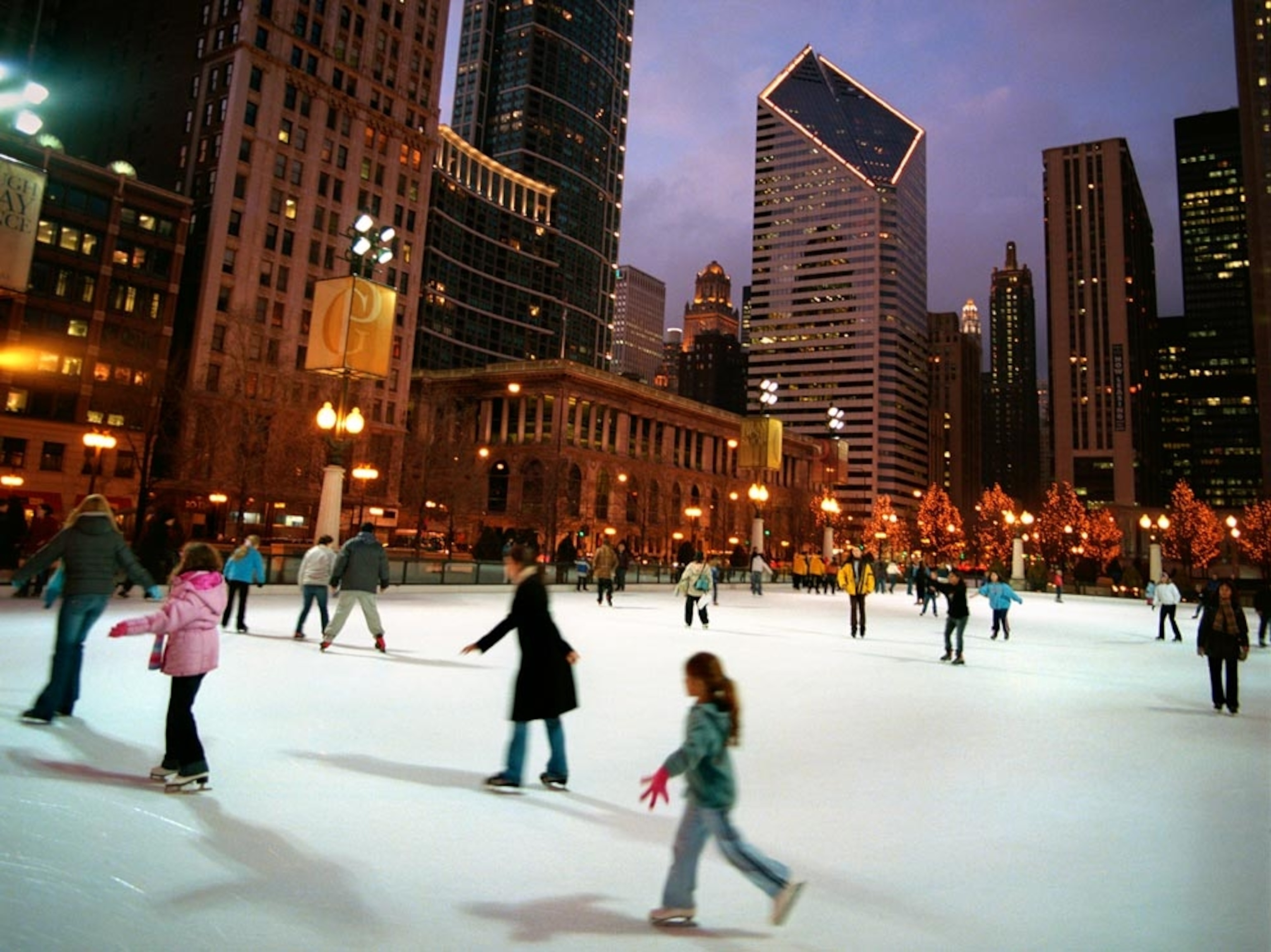 A crowd ice-skating at dusk
