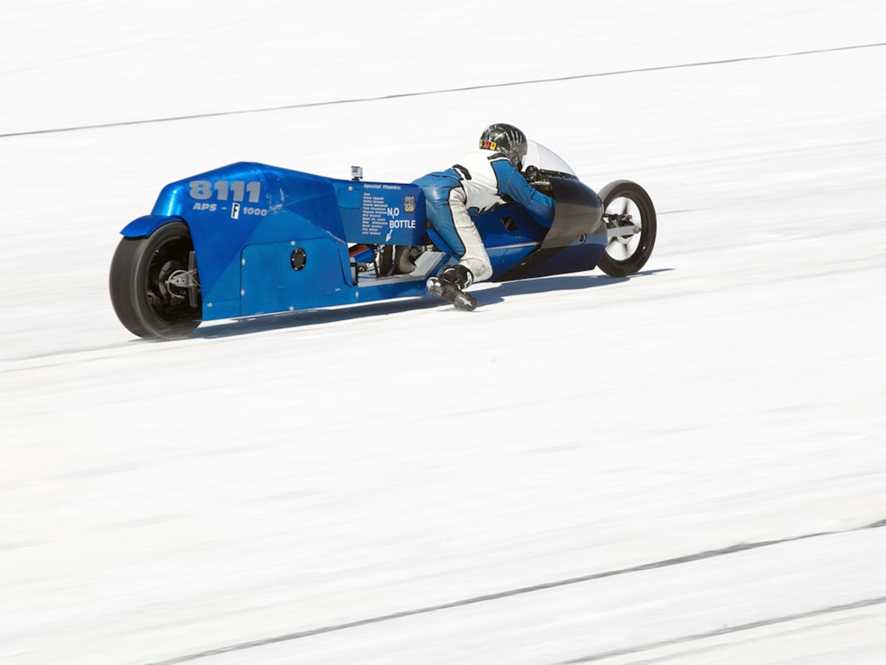 Driver racing a custom-built motorcycle