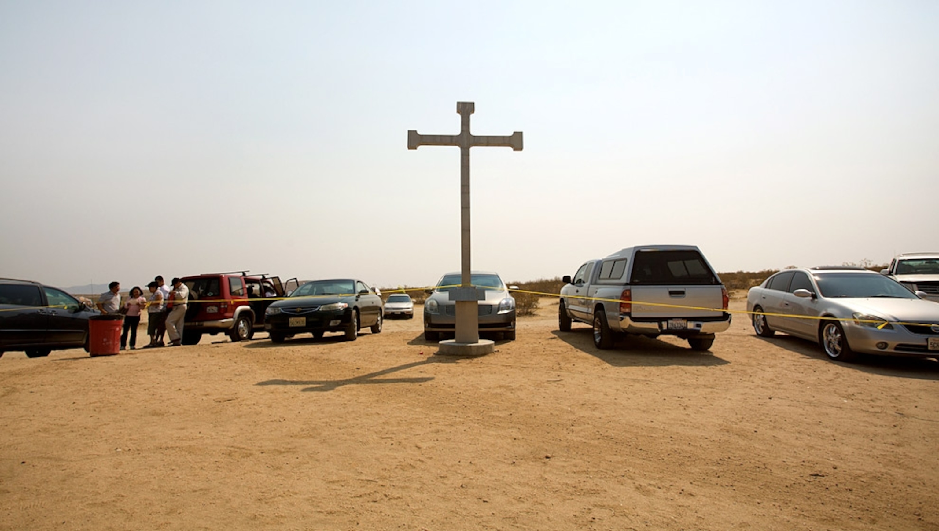 A large white cross surrounded by cars