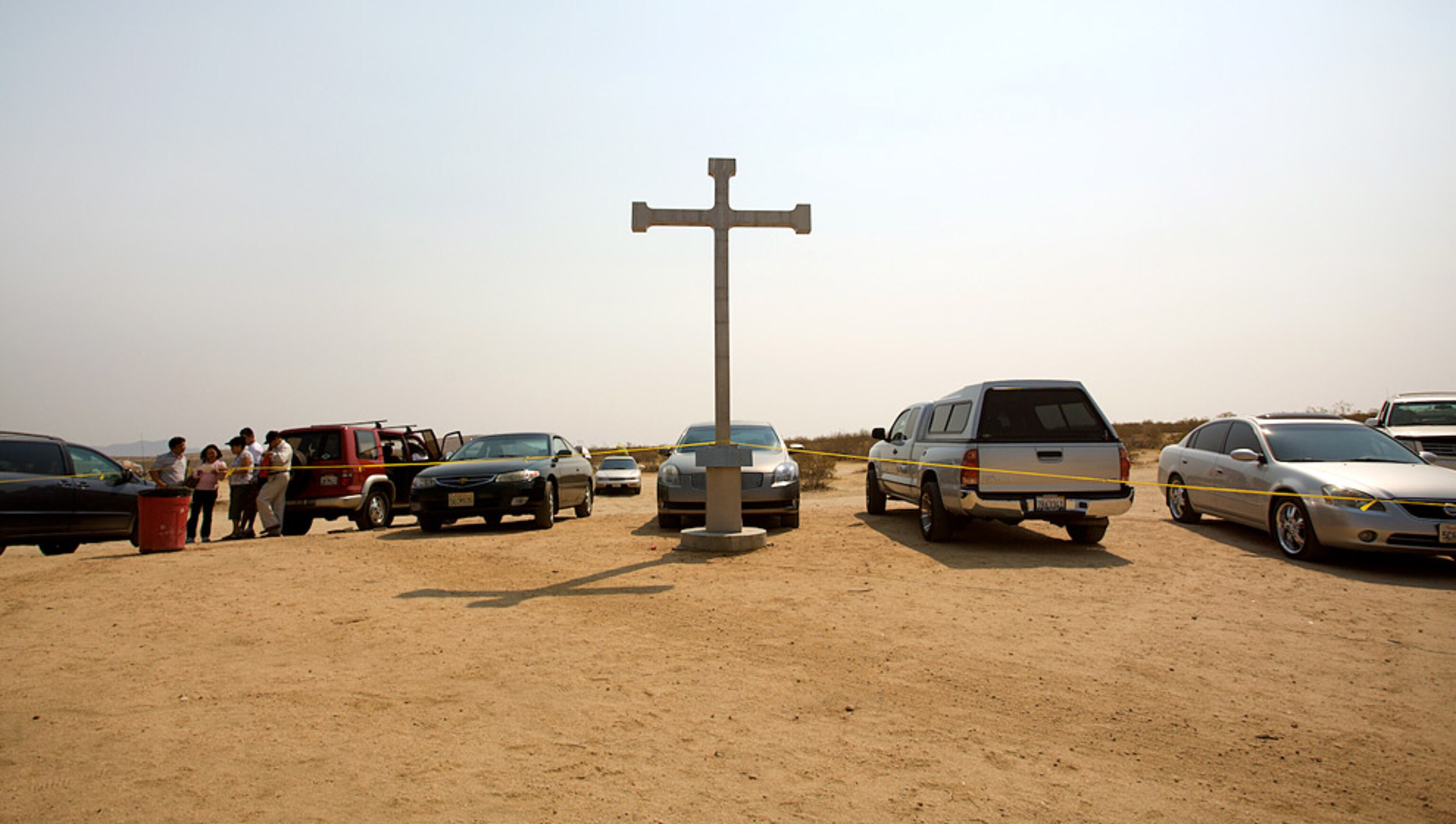 A large white cross surrounded by cars