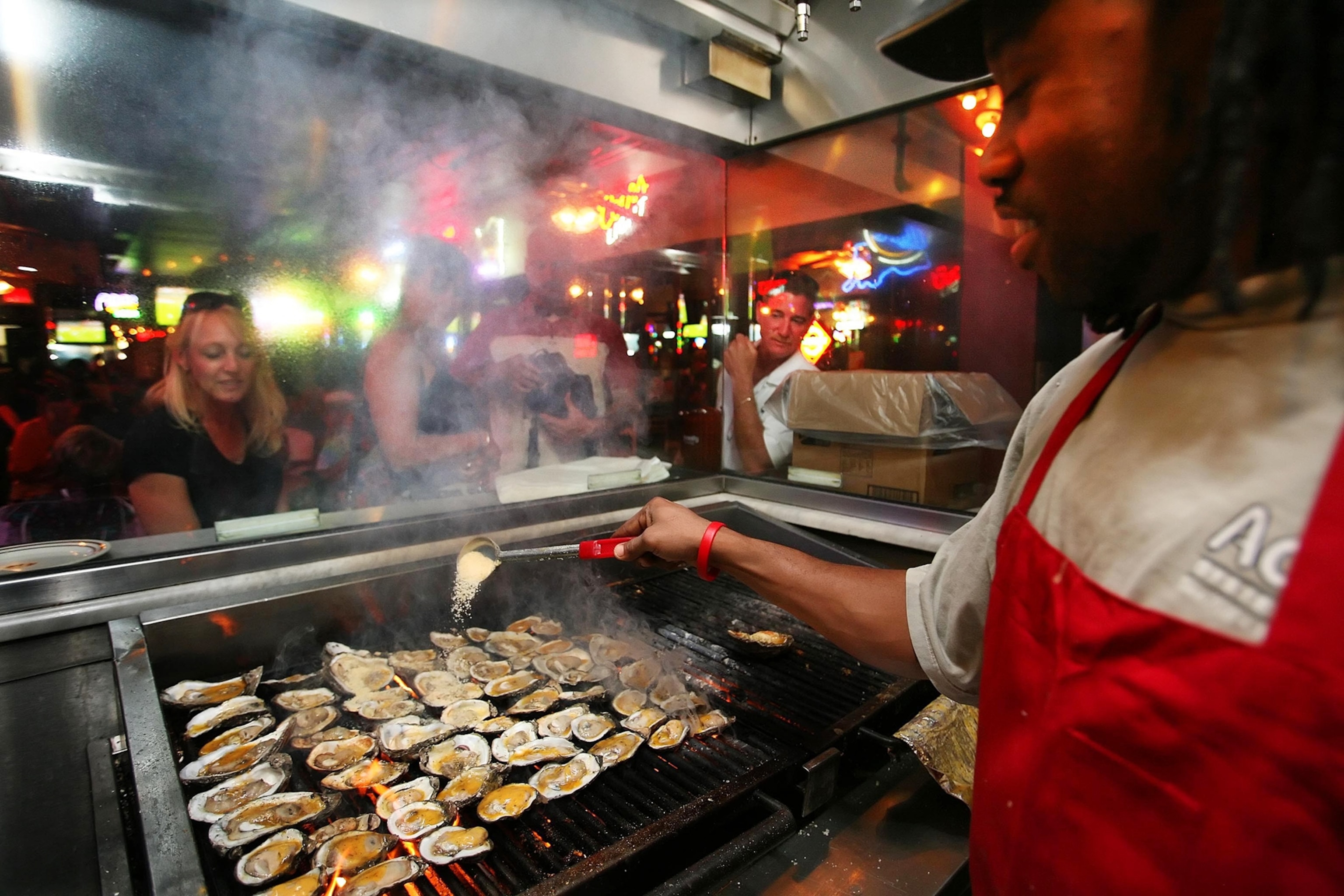 a man grilling oysters at Acme Oyster House in New Orleans