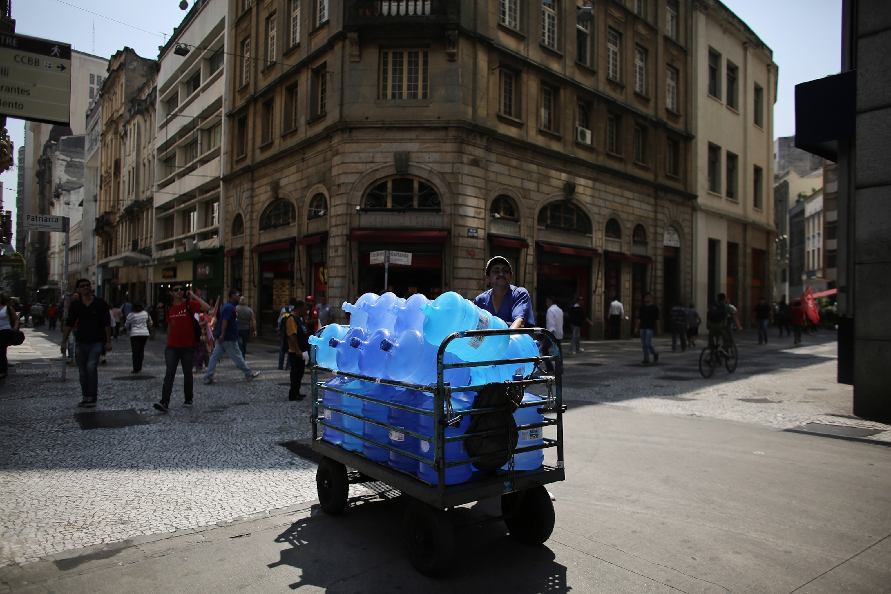 a water vendor standing next to his cart with water bottles