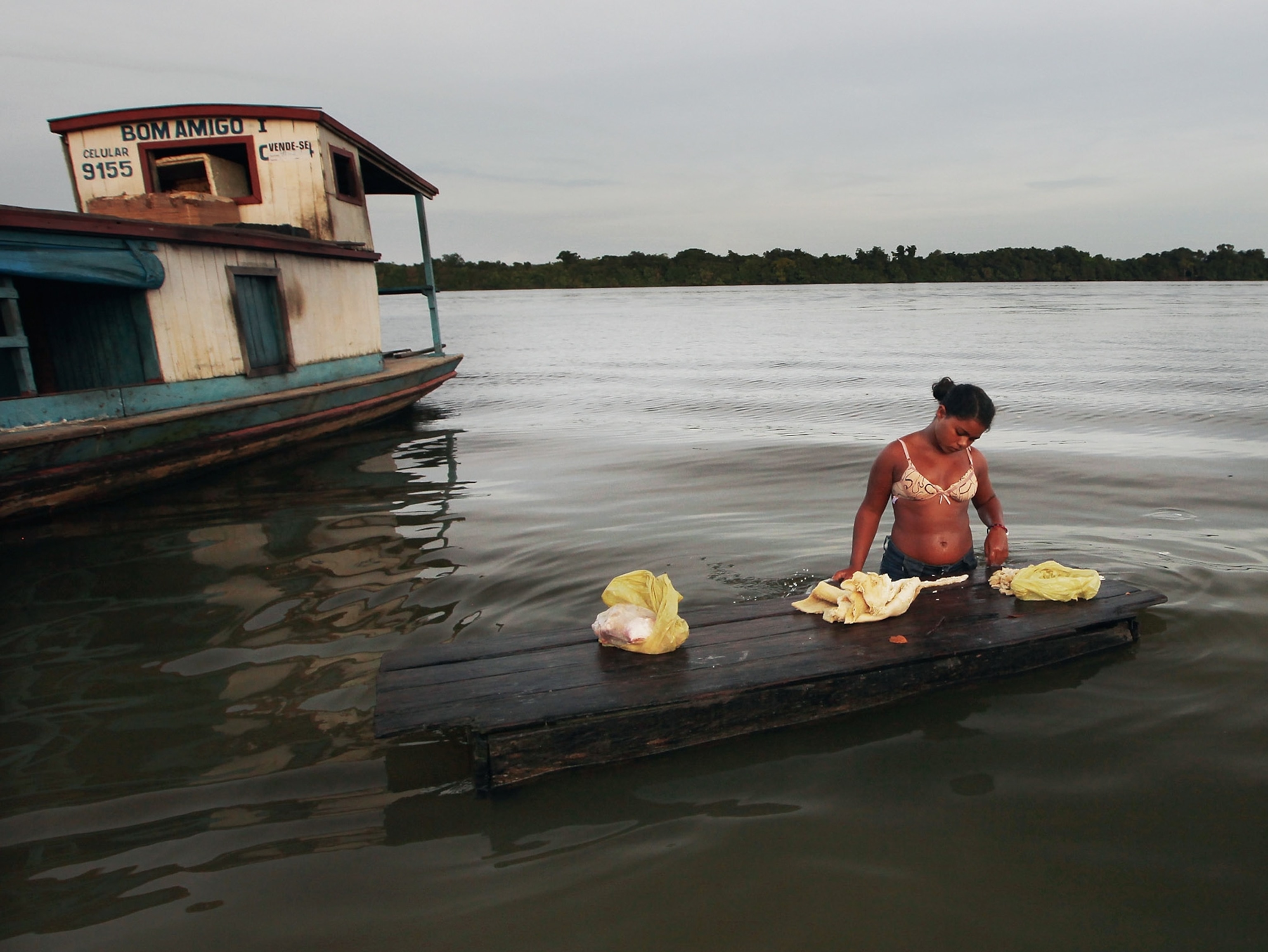 Xingu River picture - A woman prepares food in the Xingu River, Brazil
