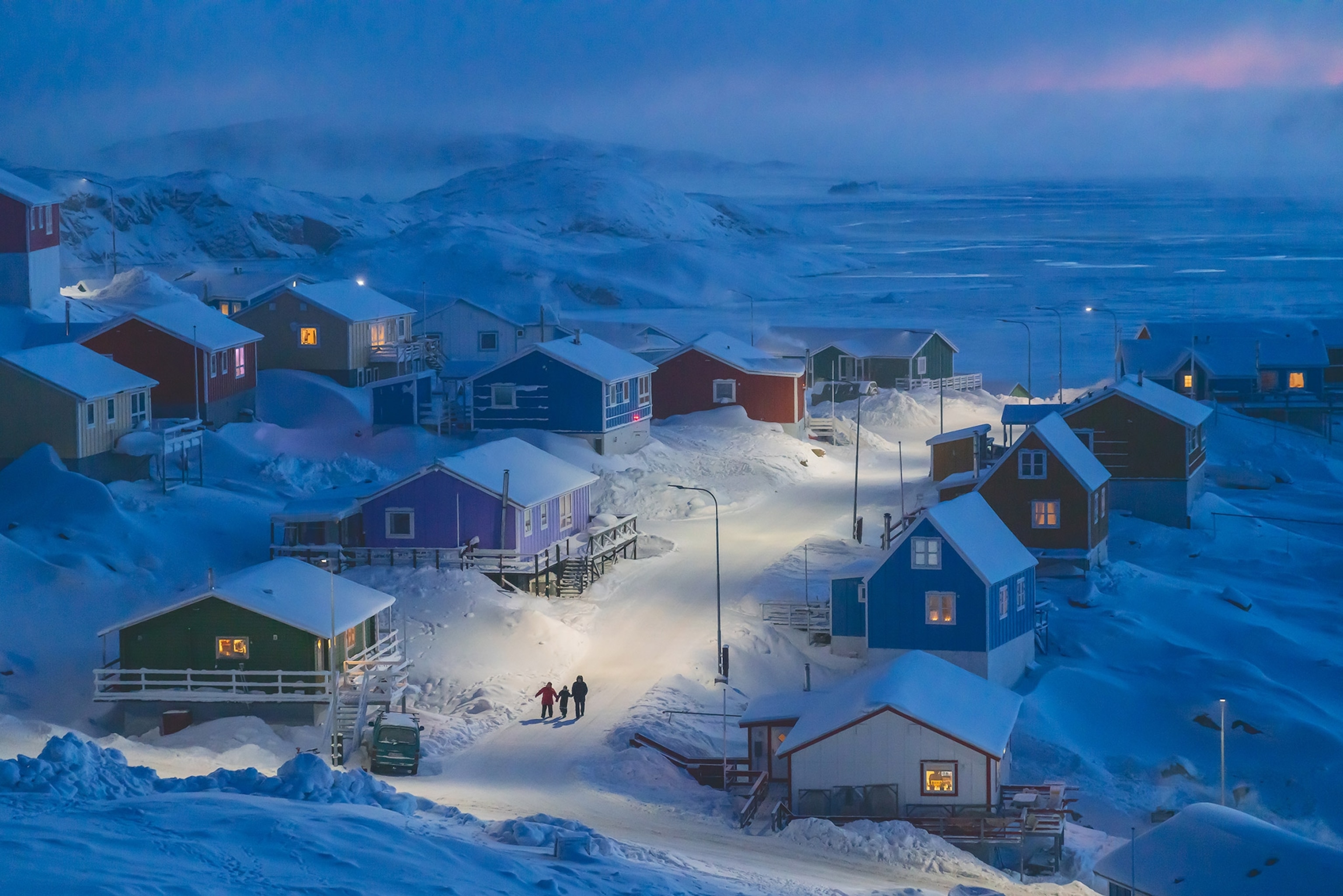 a family walking in the street in early evening in Upernavik, Greenland