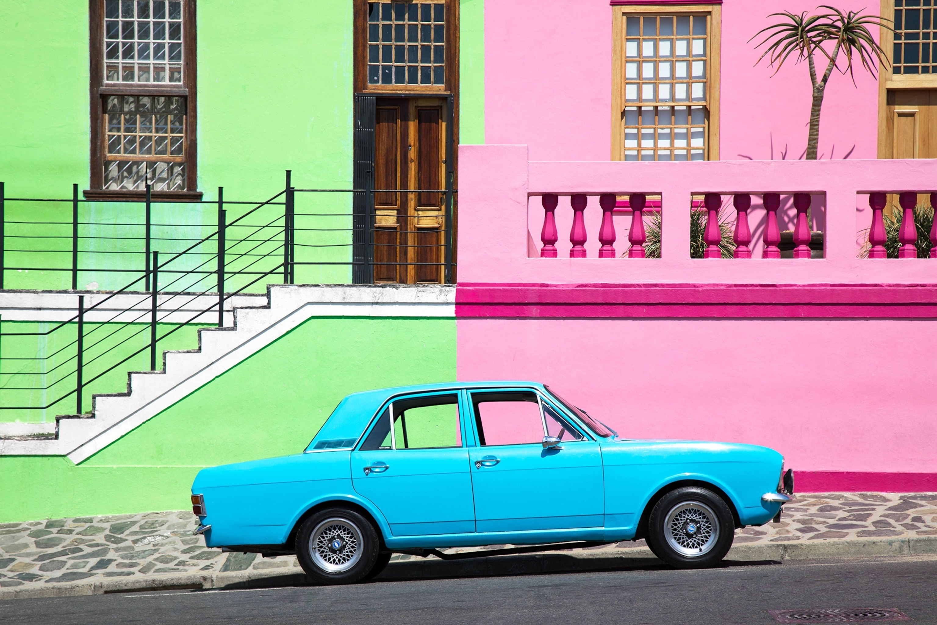 a blue car parked on a colorful street in South Africa