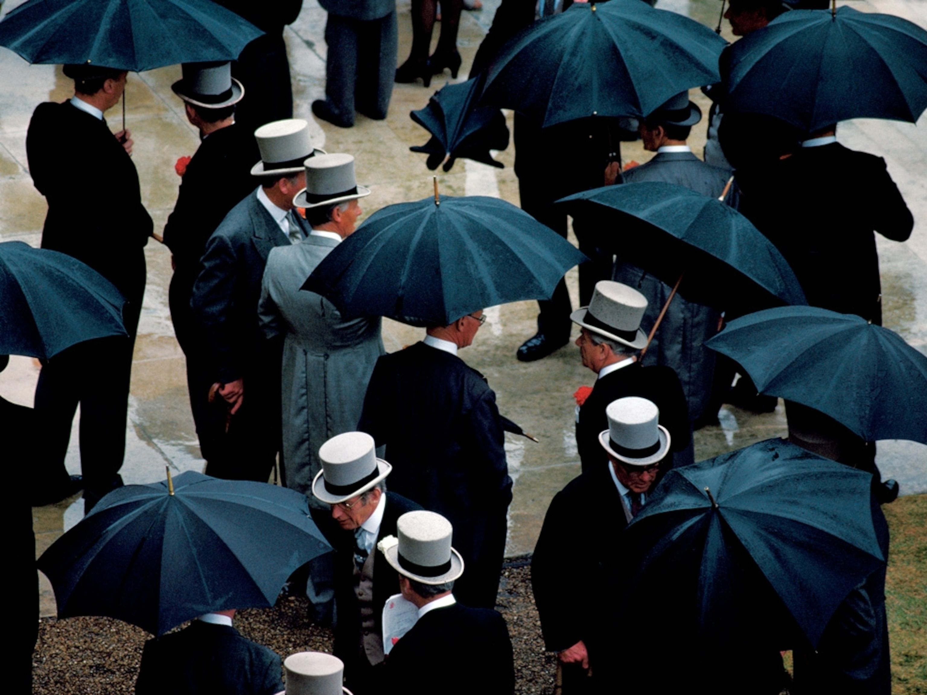 Men in suits and hats holding umbrellas