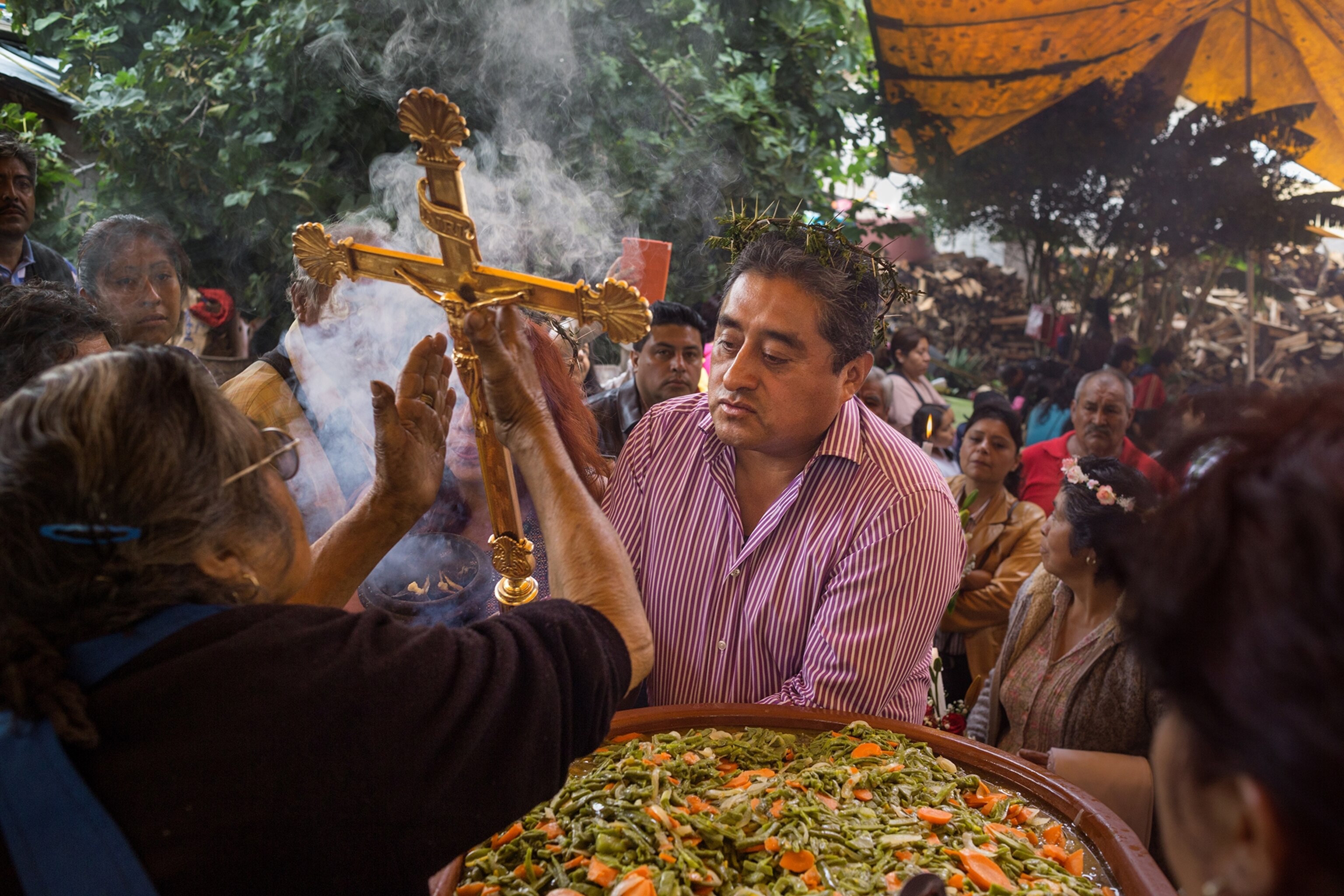The newly elected majordomo prays amid the food prepared for a town celebration. Milpa Alta, Mexico.