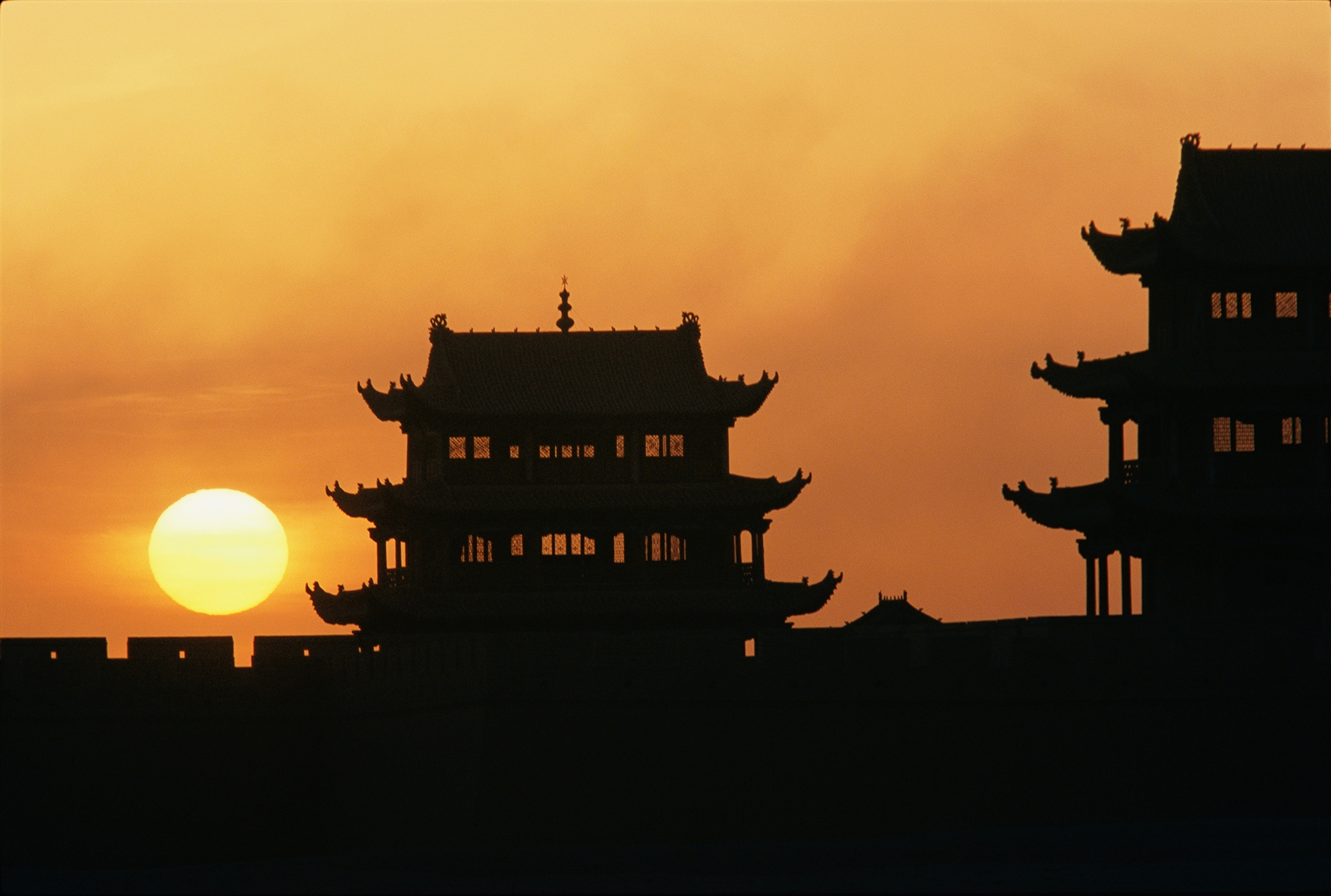 The rising sun by Jiayuguan, where a 14th century tower on the Great Wall marks a traditional entryway to China, beckoned Marco Polo to travel eastward throug h these lands.