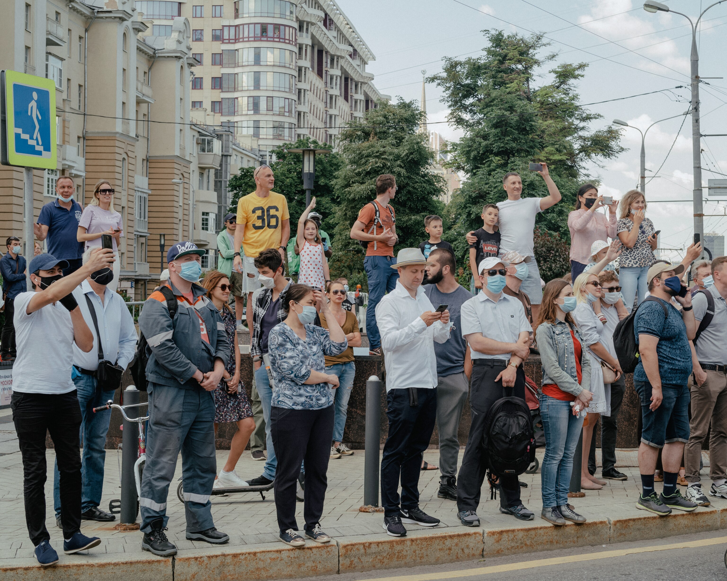 a crowd of people lining up outside watching a parade