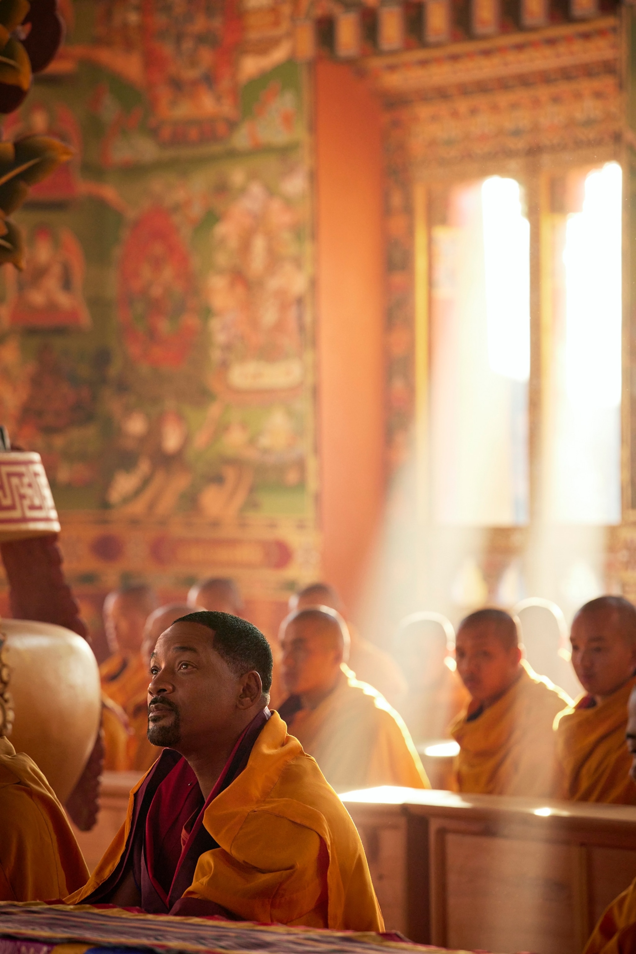 Will Smith sits in a monastery with light streaming in through the windows.