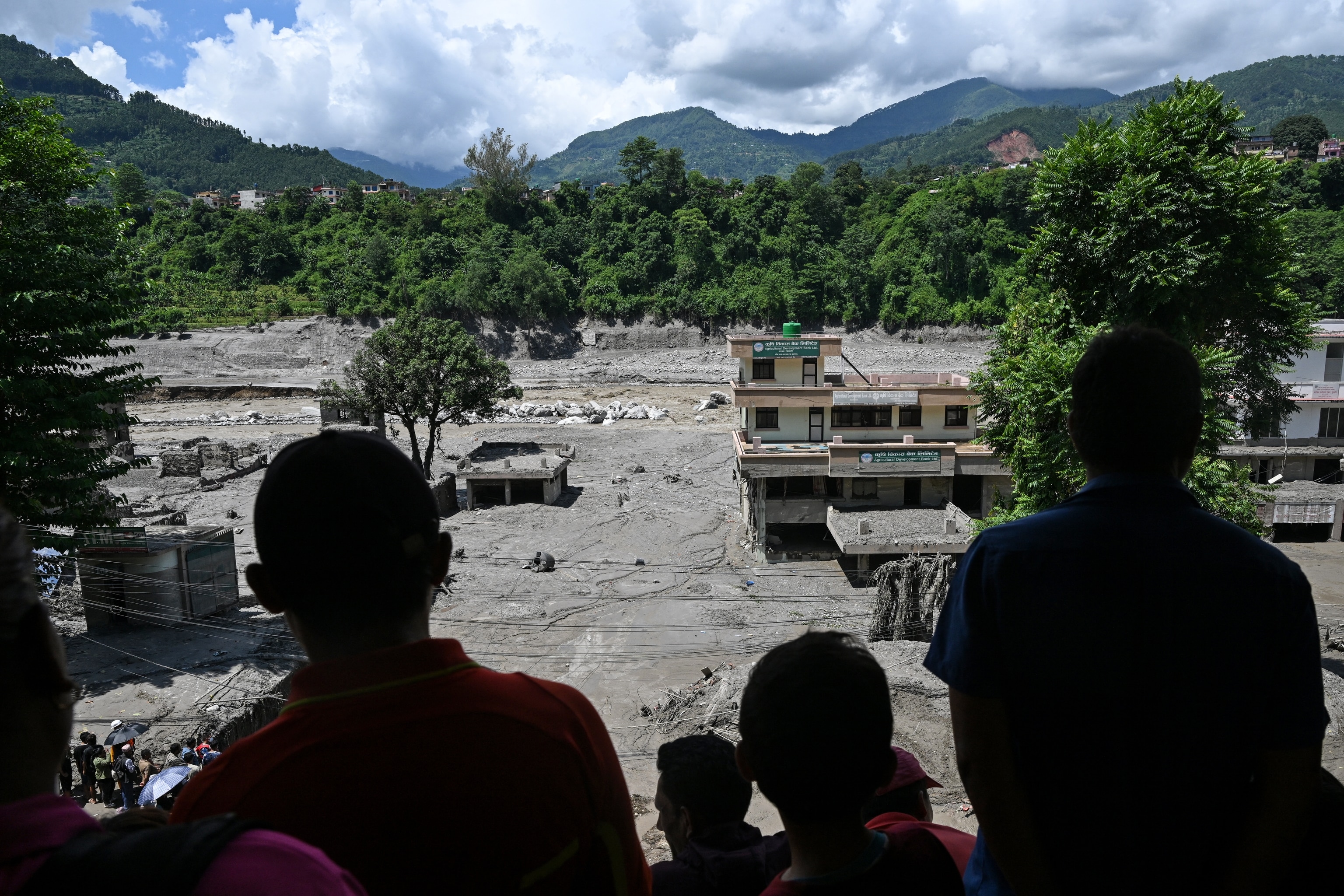People overlooking destruction from the recent mudslide in Nepal.