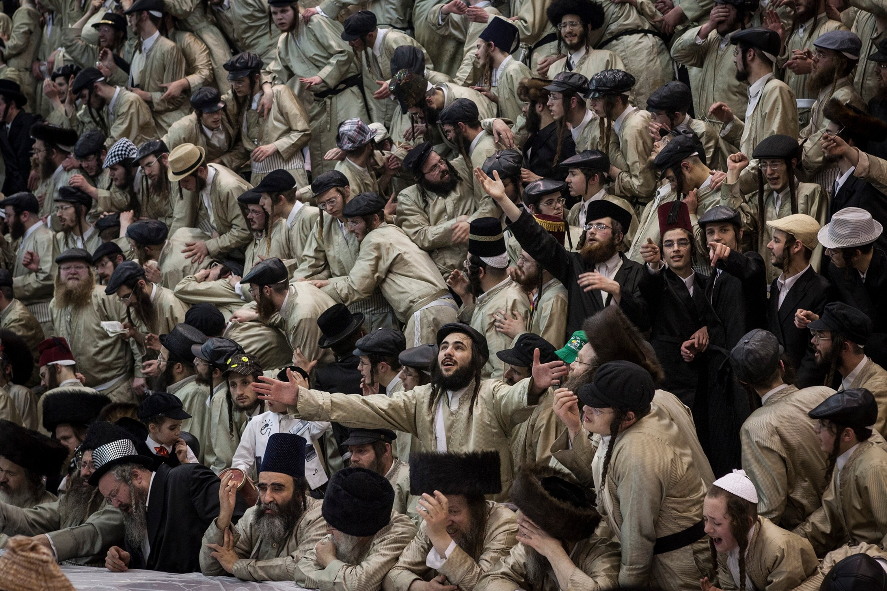 a crowd of ultra-Orthodox jews celebrating the end of Purim