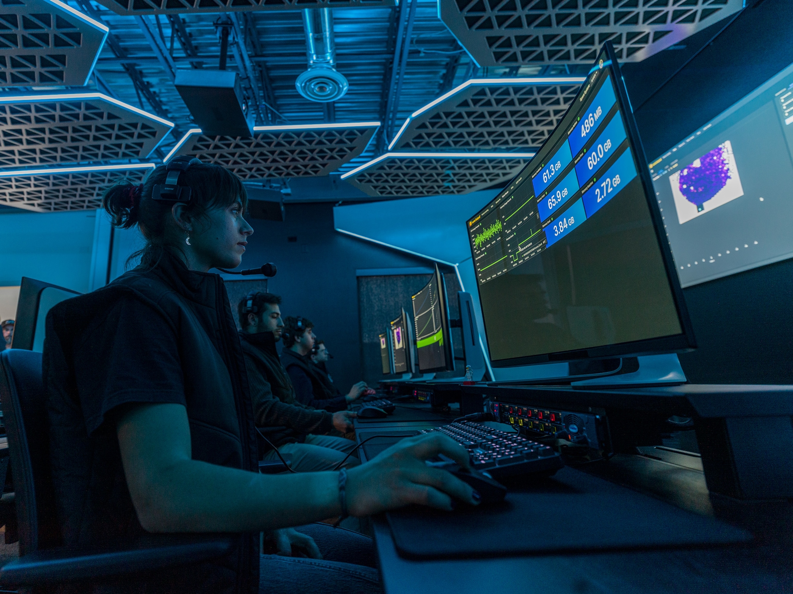 woman sitting in front of panel of screens