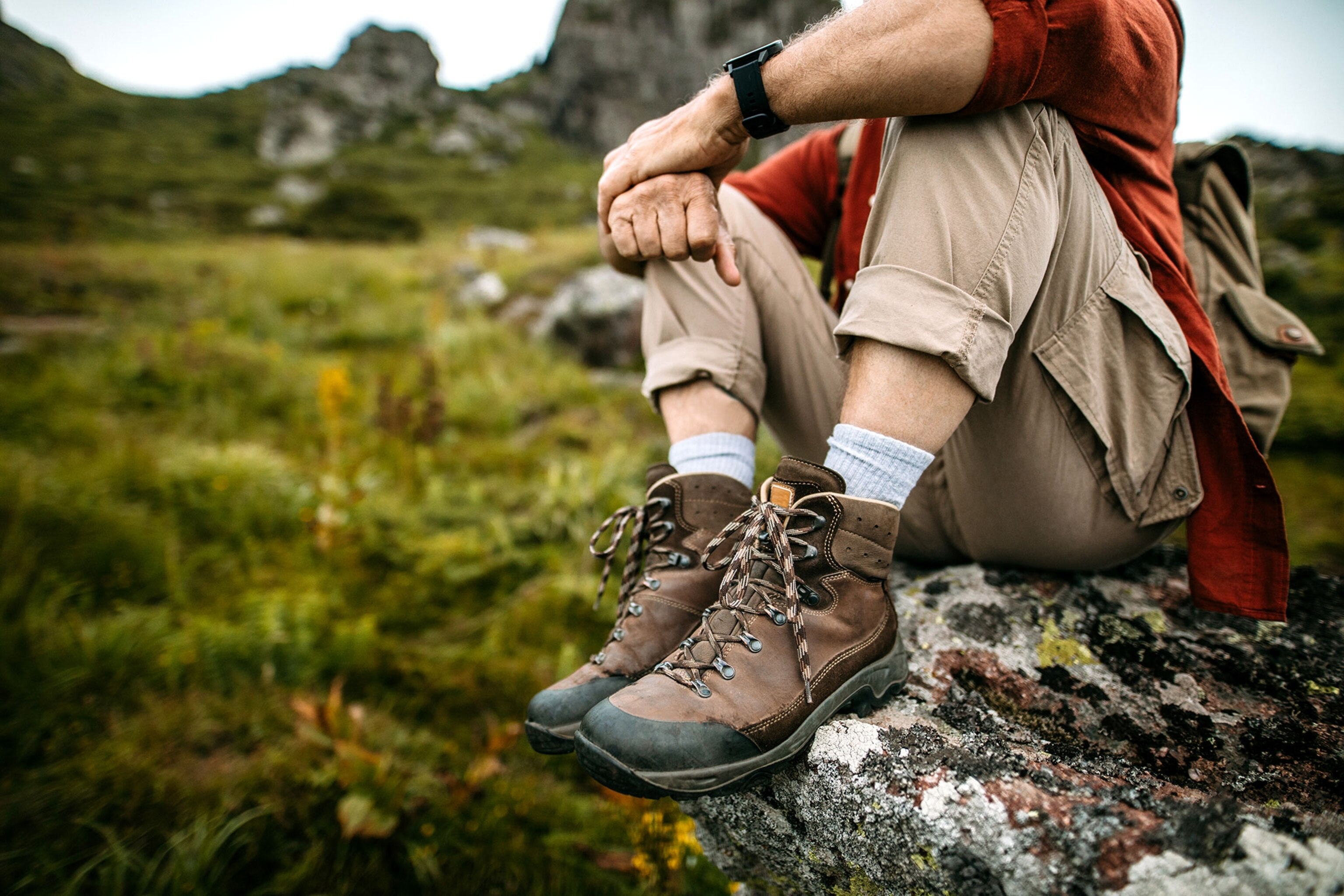 Hiker wearing proper hiking boots on mountain trail with backpack
