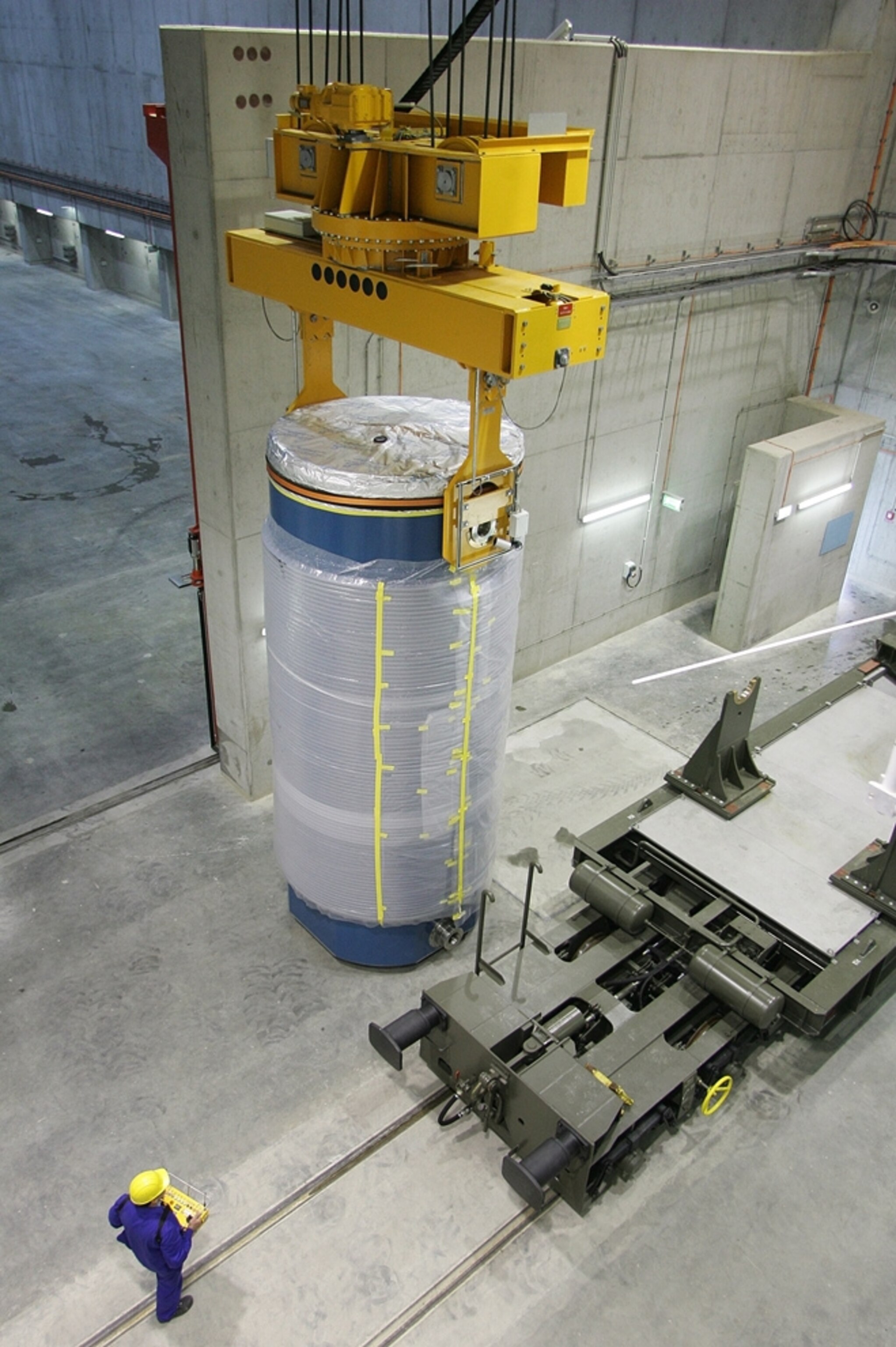 A robotic system moves a canister of nuclear waste high above the floor of a storage facility (picture)
