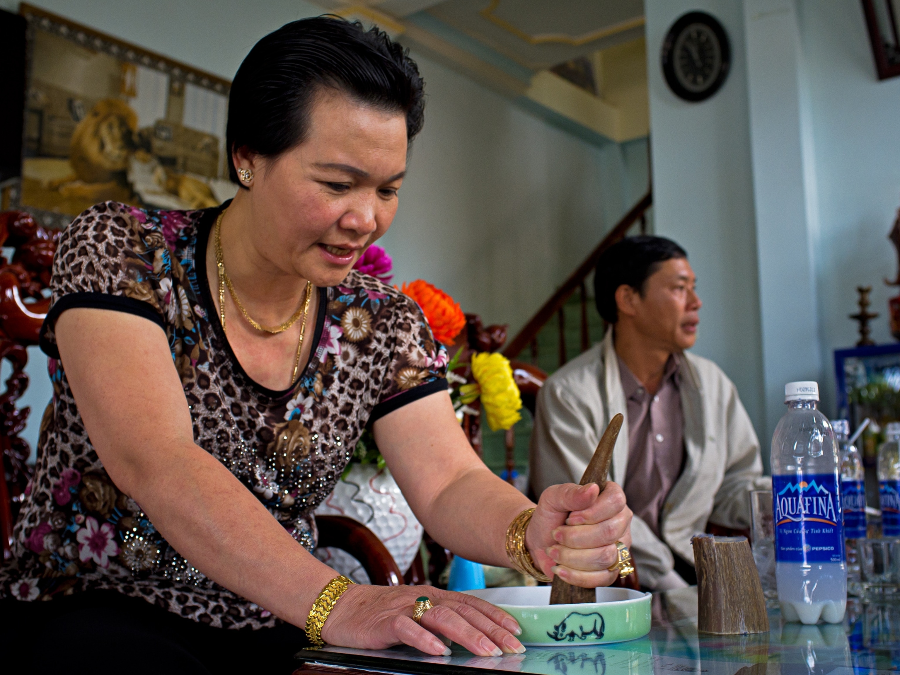 In a cafe in Vietnam, a woman grinds a piece of rhino horn.